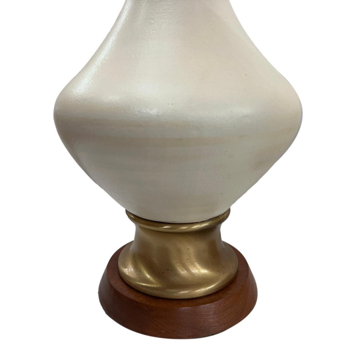 Coppia di lampade da tavolo in ceramica italiana degli anni '60 circa con base in legno.

Misure:
Altezza del corpo: 20
Altezza del paralume: 28