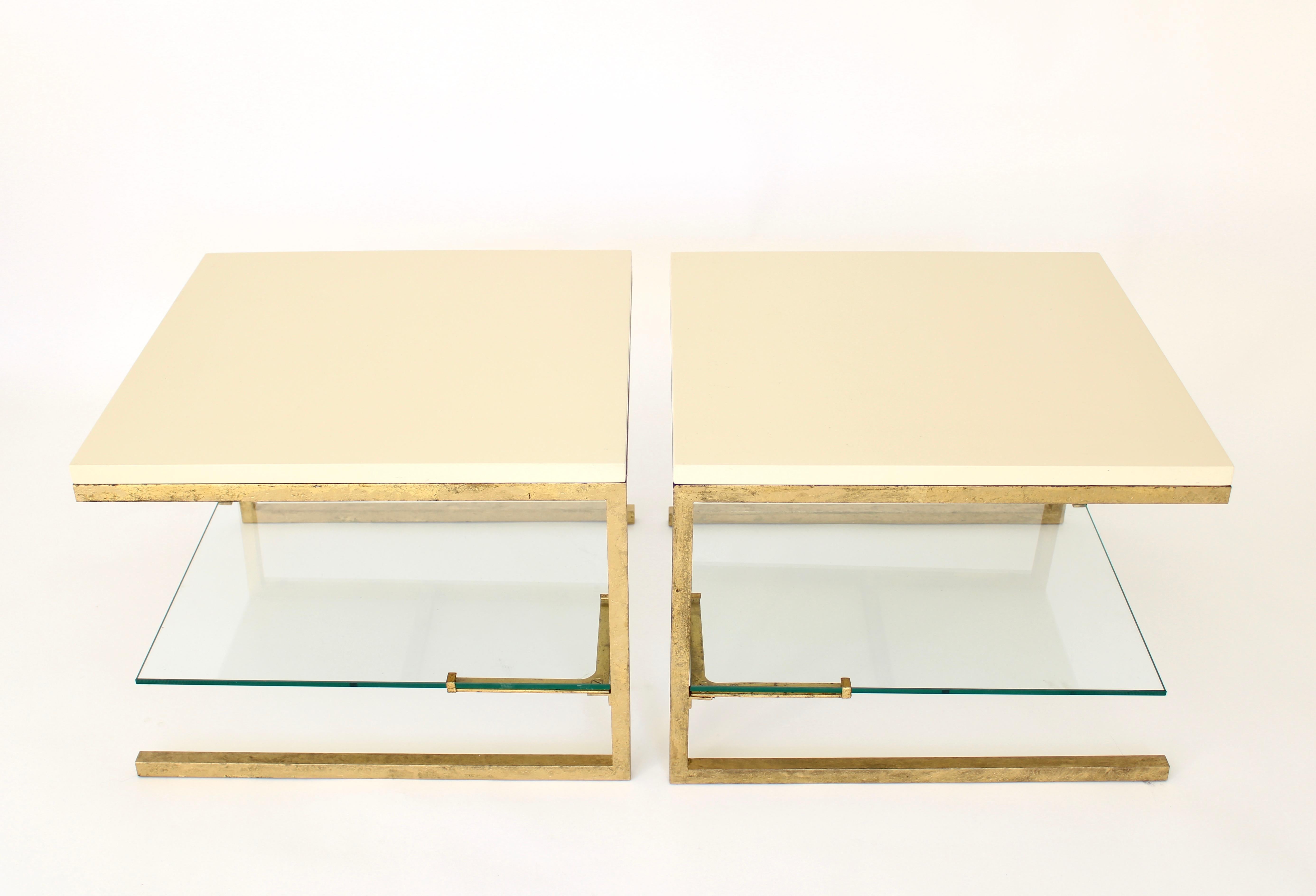 Pair of French Maison Ramsay side tables with cream or ivory color lacquered tops set on gilded iron frames with a semi floating glass second shelf.
The lacquered plateau is 1