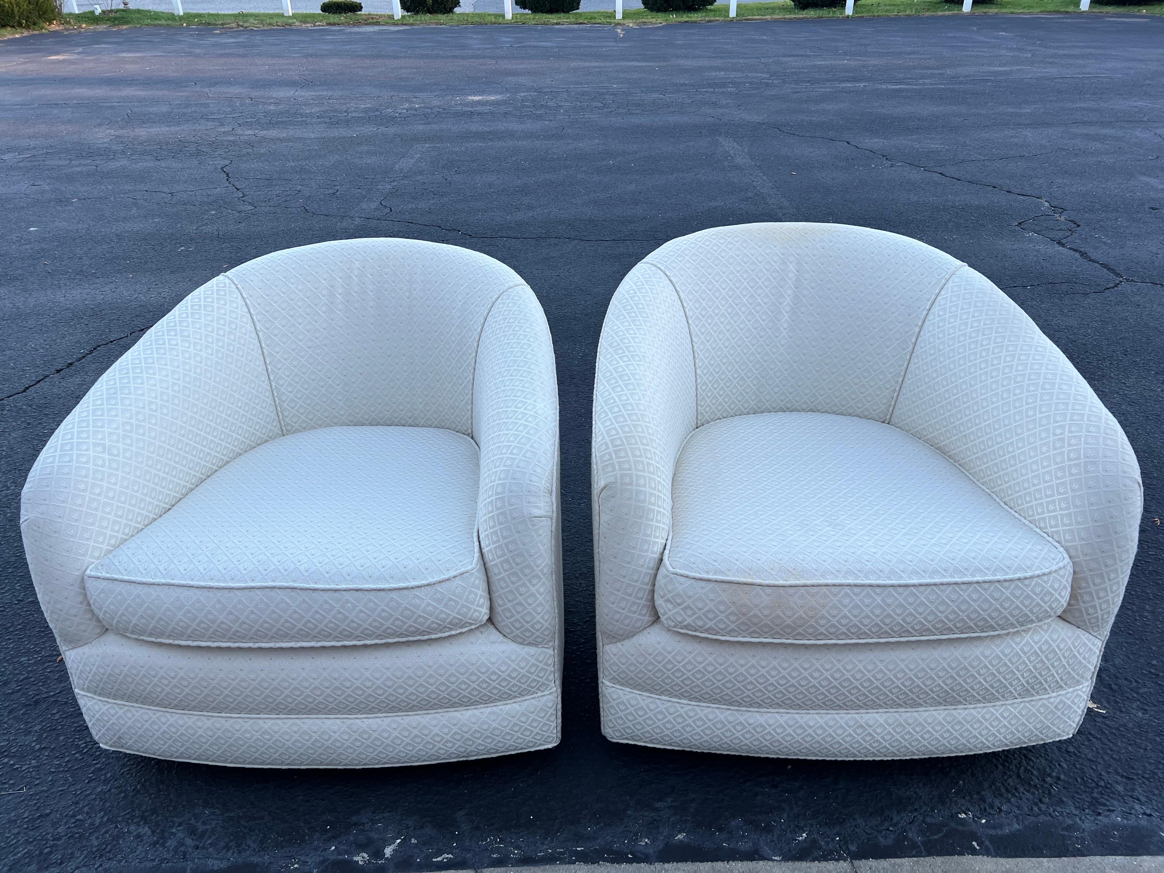 Pair of Creamy White Swivel Cube Chairs. Classic, timeless styling. Nice neutral pair with durable upholstery. One chair has a swivel and the other has a swivel and a rocker. Although one can easily change the rocker to just a swivel base if needed. 