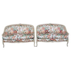 Paar cremefarbene, verzierte, geblümte gepolsterte französische Louis-XV-Settees im Louis-XV-Stil