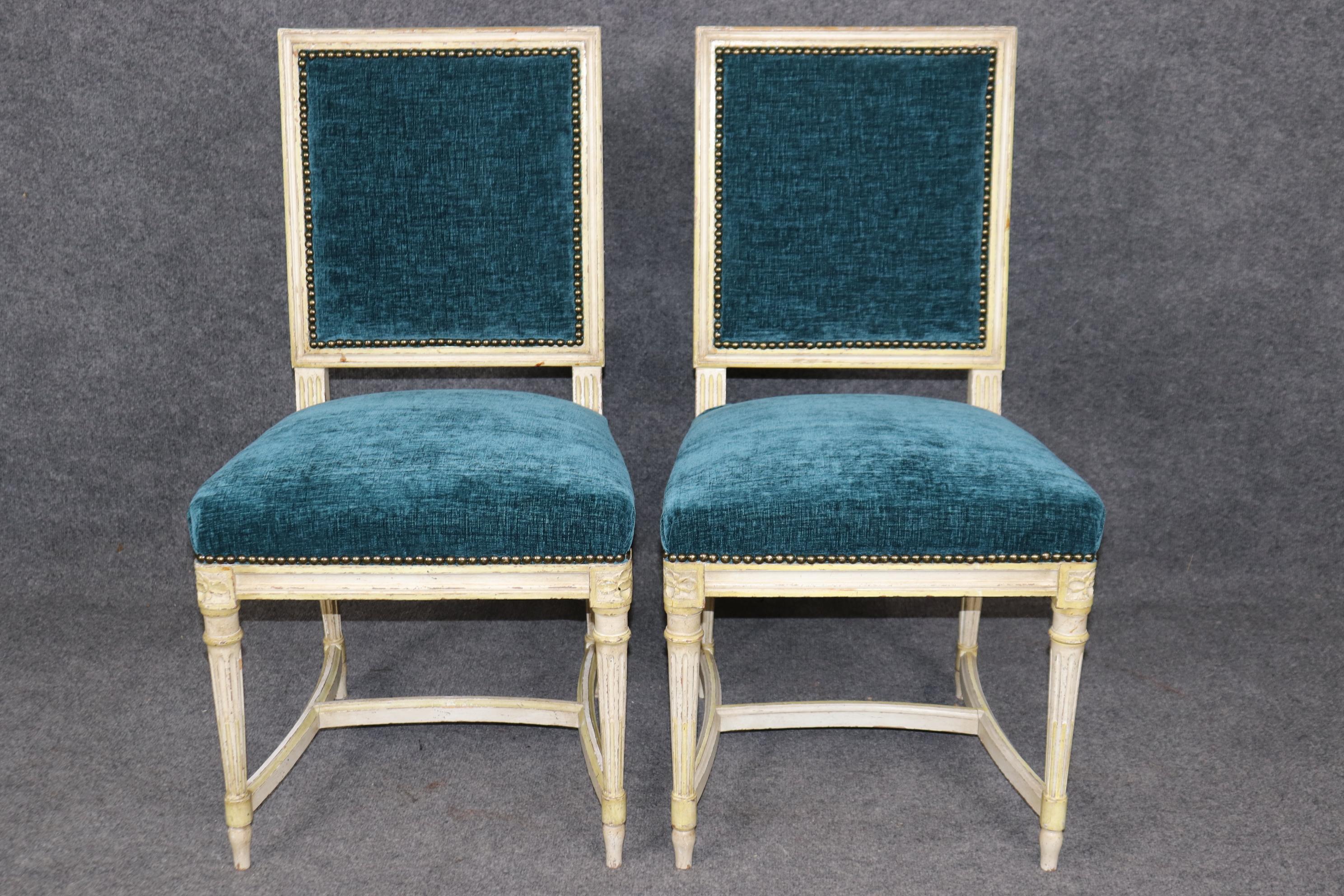 Il s'agit d'une paire de chaises d'appoint de style Louis XVI, peintes en crème et avec des garnitures peintes en jaune. Ils sont parfaits pour le coin d'une pièce ou une entrée. Ils sont en bon état, avec une belle sellerie en velours bleu