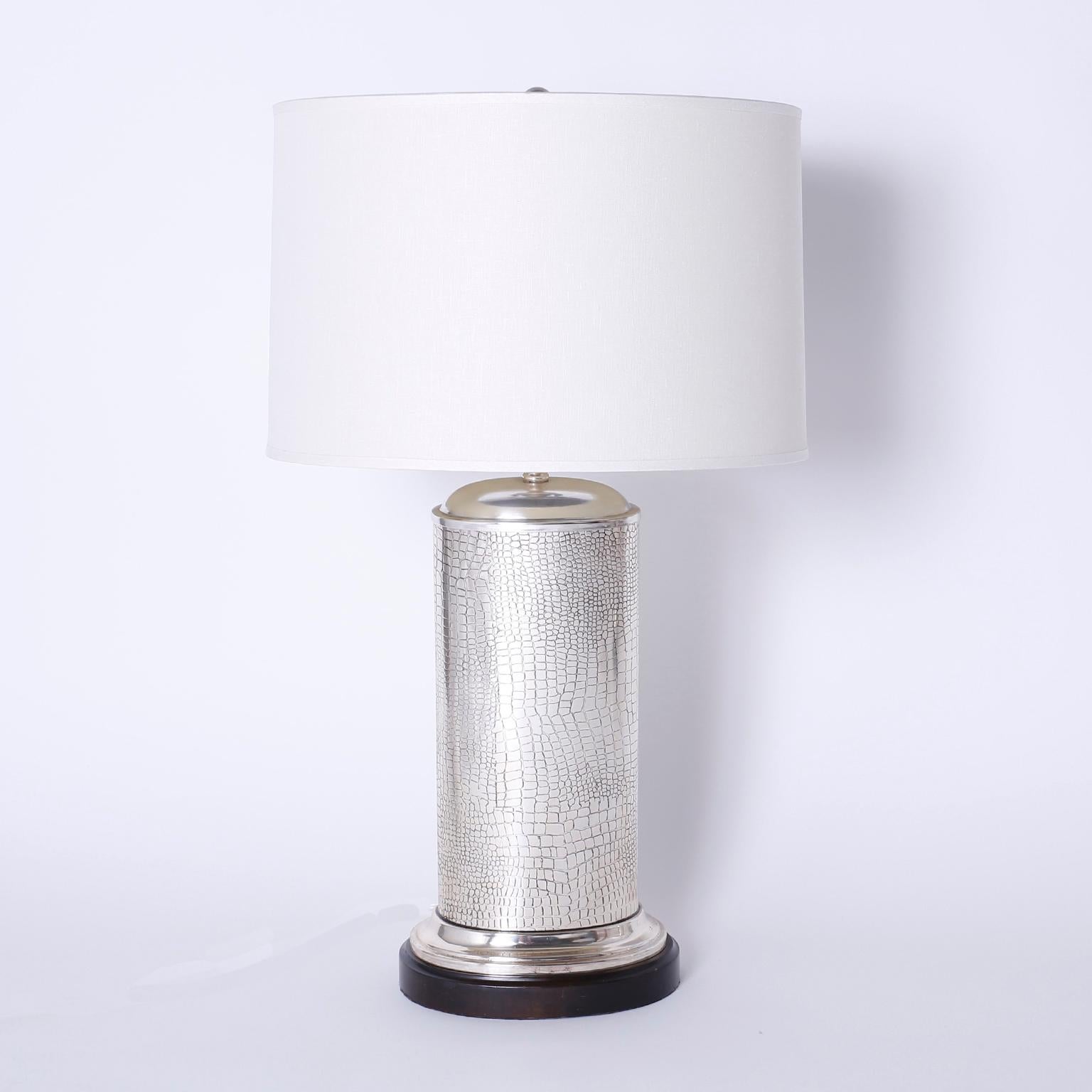 Elegante par de lámparas de sobremesa de mediados de siglo con forma cilíndrica de cocodrilo de imitación niquelado, presentadas sobre bases de madera ebonizada.
 