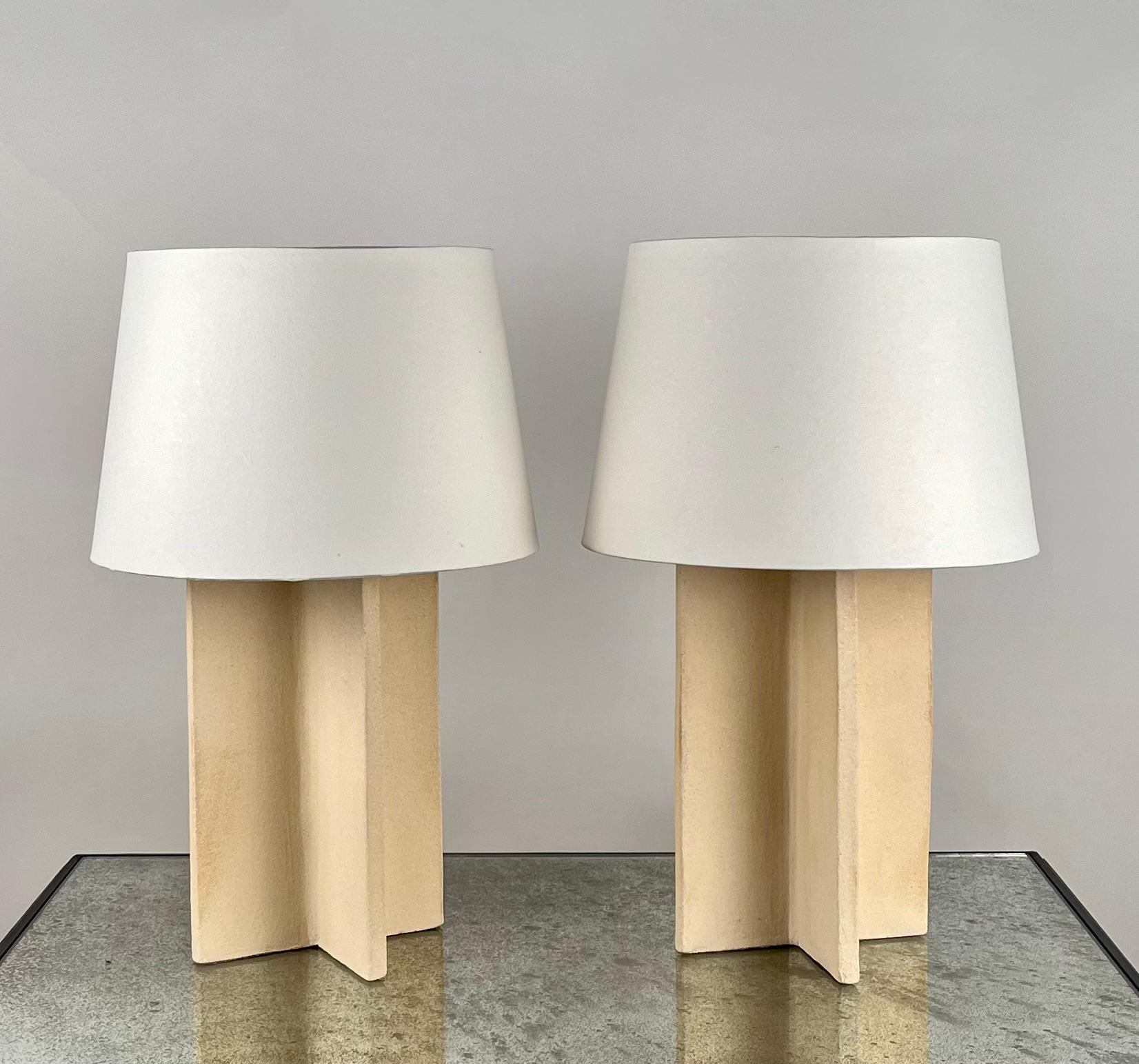 Pair of chic Croisillon cream ceramic lamps with parchment shades by Design Frères.

An attractive, understated combination of ceramic crosspiece bases with a cream matte glaze and European style parchment shades (no harps or finials).

Dimensions