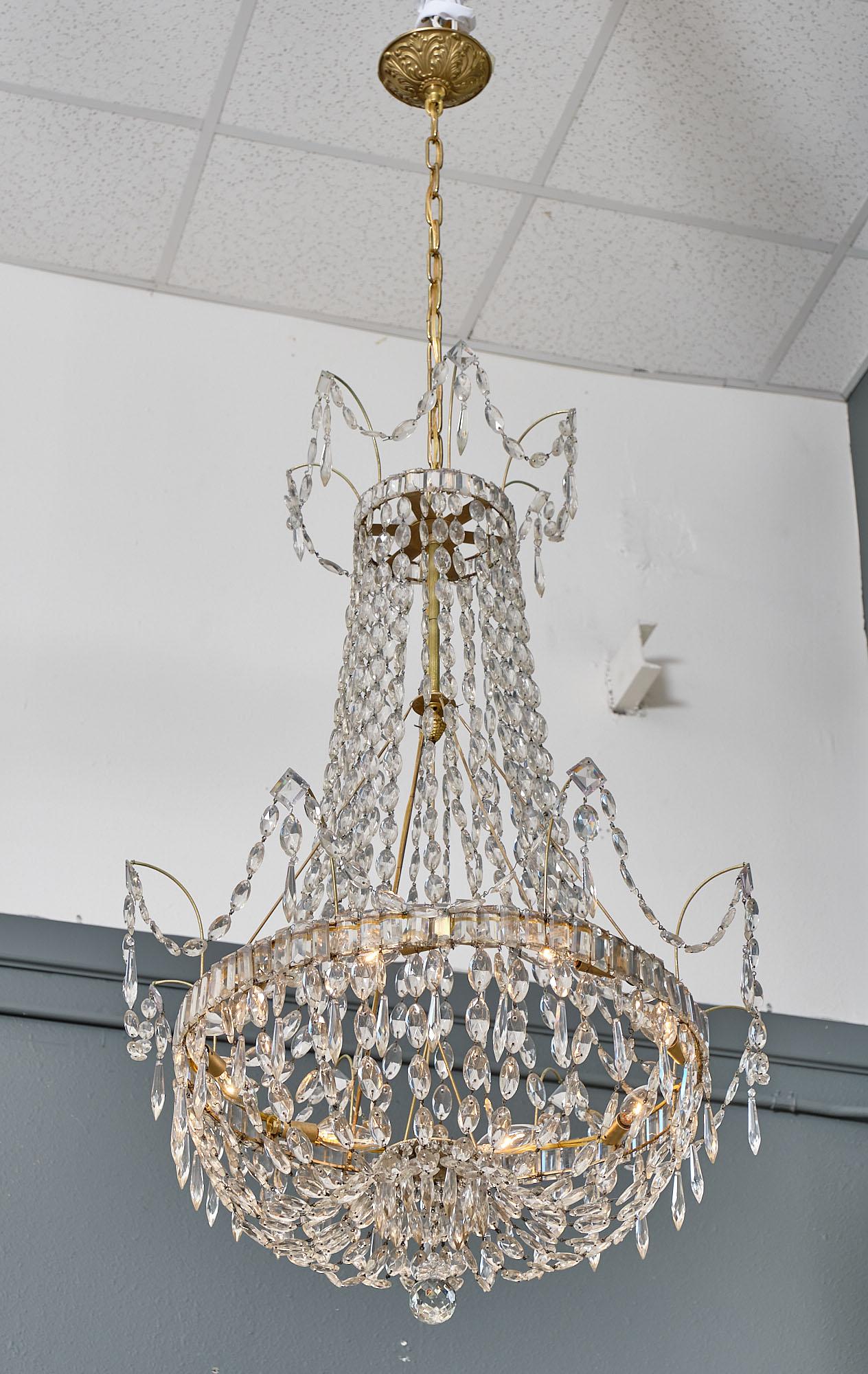 Pair of chandeliers from France. This rare pair of fixtures feature multiple cut crystal strands and pendants. Wired to fit US standards.