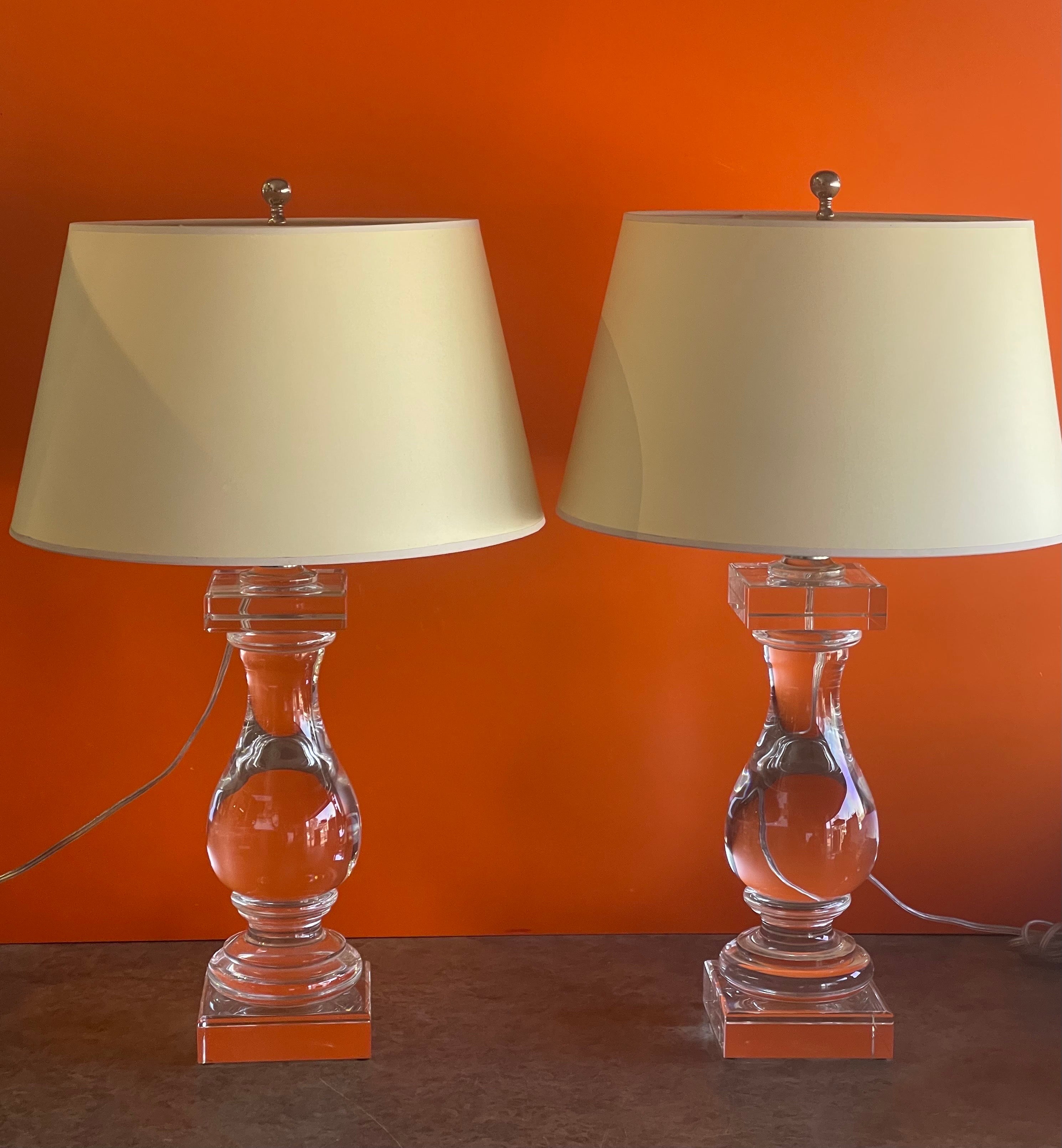 Stunning pair of crystal balustrade table lamps by Chapman & Myers for Visual Comfort, circa 2000s. The lamp base is made of thick heavy crystal (each lamp weighs over 20 pounds!!) and comes with a natural paper shade The lamps are in very good