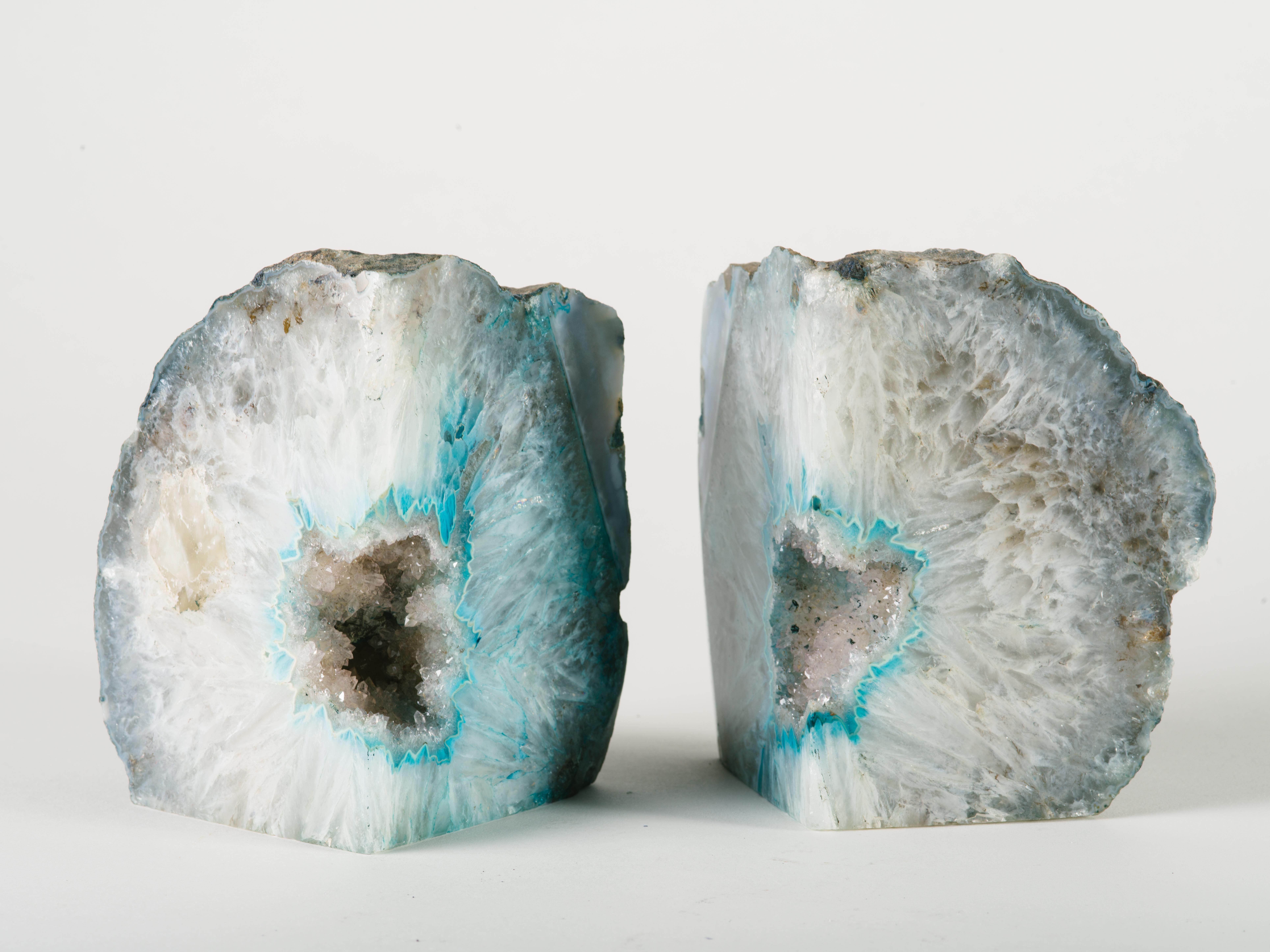 Exquisite pair of hand-carved semi precious gemstone bookends with white crystalline centers. Hand polished quartz geode with natural streaks in hues of teal and turquoise. Allows for multiple configurations and are beautiful from all angles. Rough