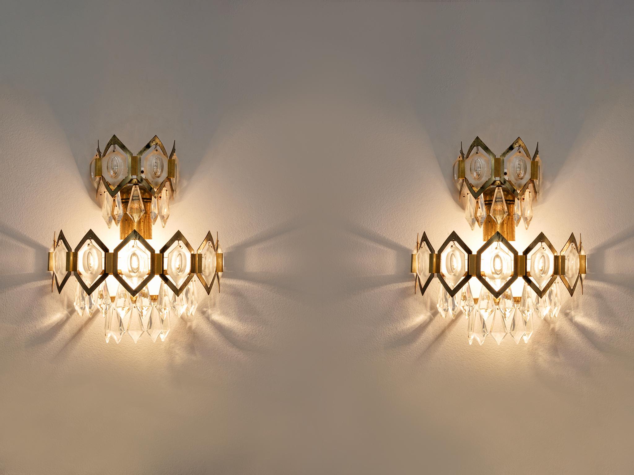 Pair of wall lights, in glass and brass, European 1960s

Pair of crystal sconces with brass fixture. These wall lights come with the elegance of royal lighting. The brass frame reminds of a crown. In combination with the frosted glass icicles, these