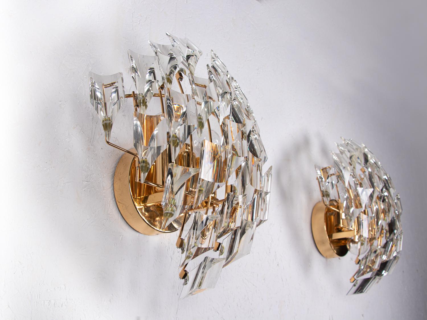 Elegant pair of wall lights with crystal glass on a gold-plated brass frame. 
With this light you make a clear statement in your interior design. A real eye-catcher even unlit. 

Designed by Oscar Torlasco, manufactured by Stilkronen, Italy in the
