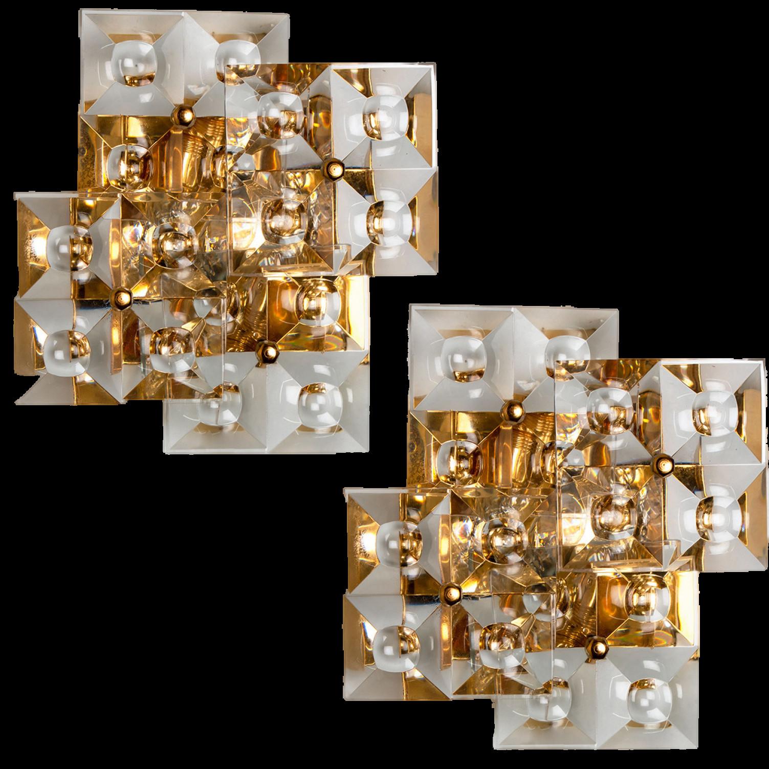 Pair of  golden sconces with crystal glasses, made by Kinkeldey, Germany, circa 1970-1979.
It’s composed of four square crystal glass pieces on a gilded brass frame. Best of the 1970s from Germany.
In excellent vintage
