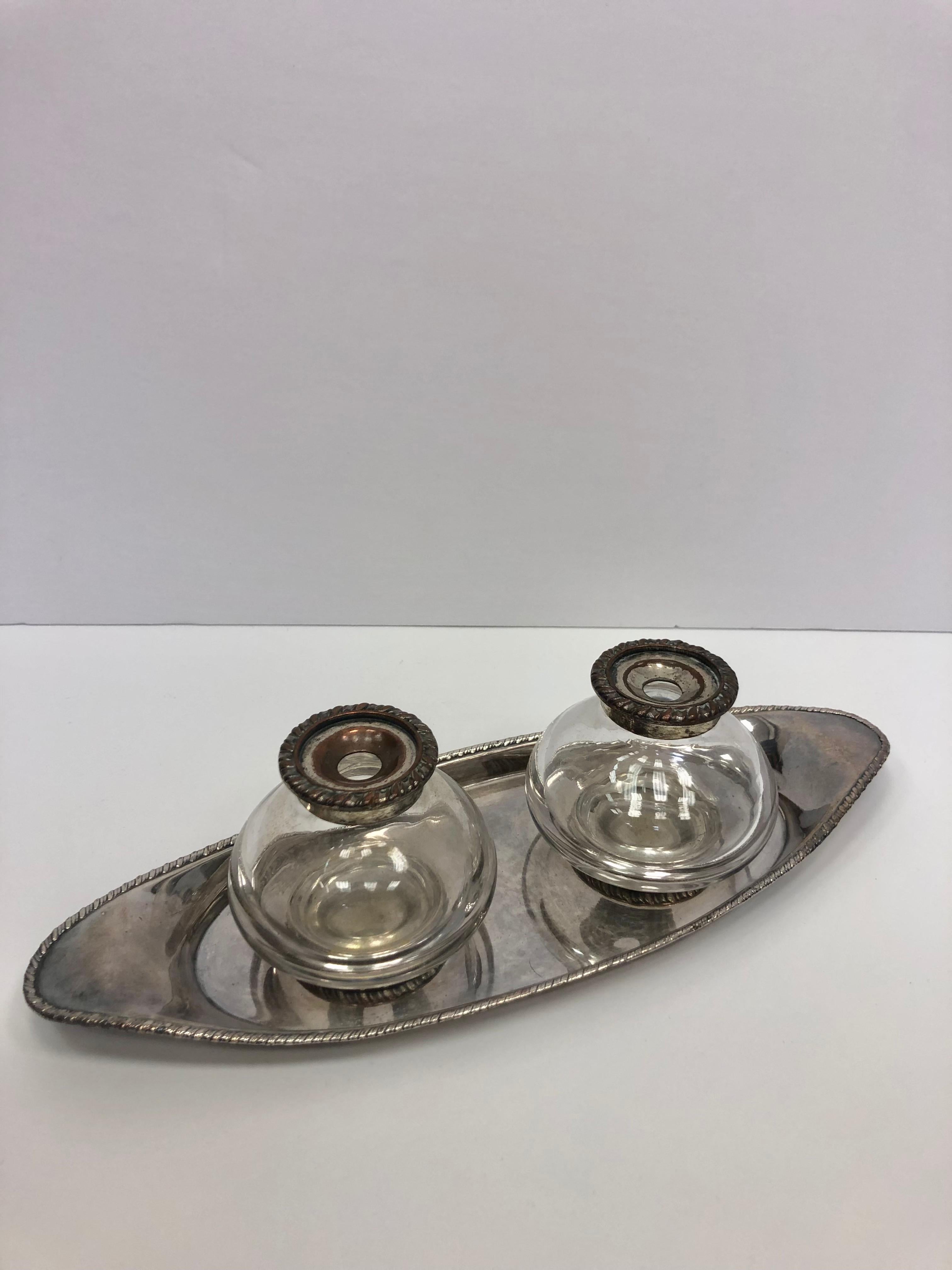 Beautiful pair of crystal inkwells on an oval silver plated tray. The tray has a nice rope detailing. Circa 1890 England.