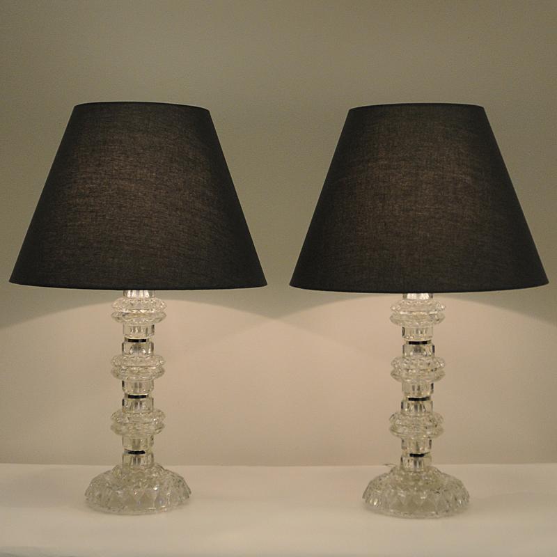 A midcentury pair of beautiful and decorative crystalglass table lamps with foliate deep relief details and polished chrome. These vintage lamps have a solid large base with a pole decorated with chrome rings, and they fit beautifully in every