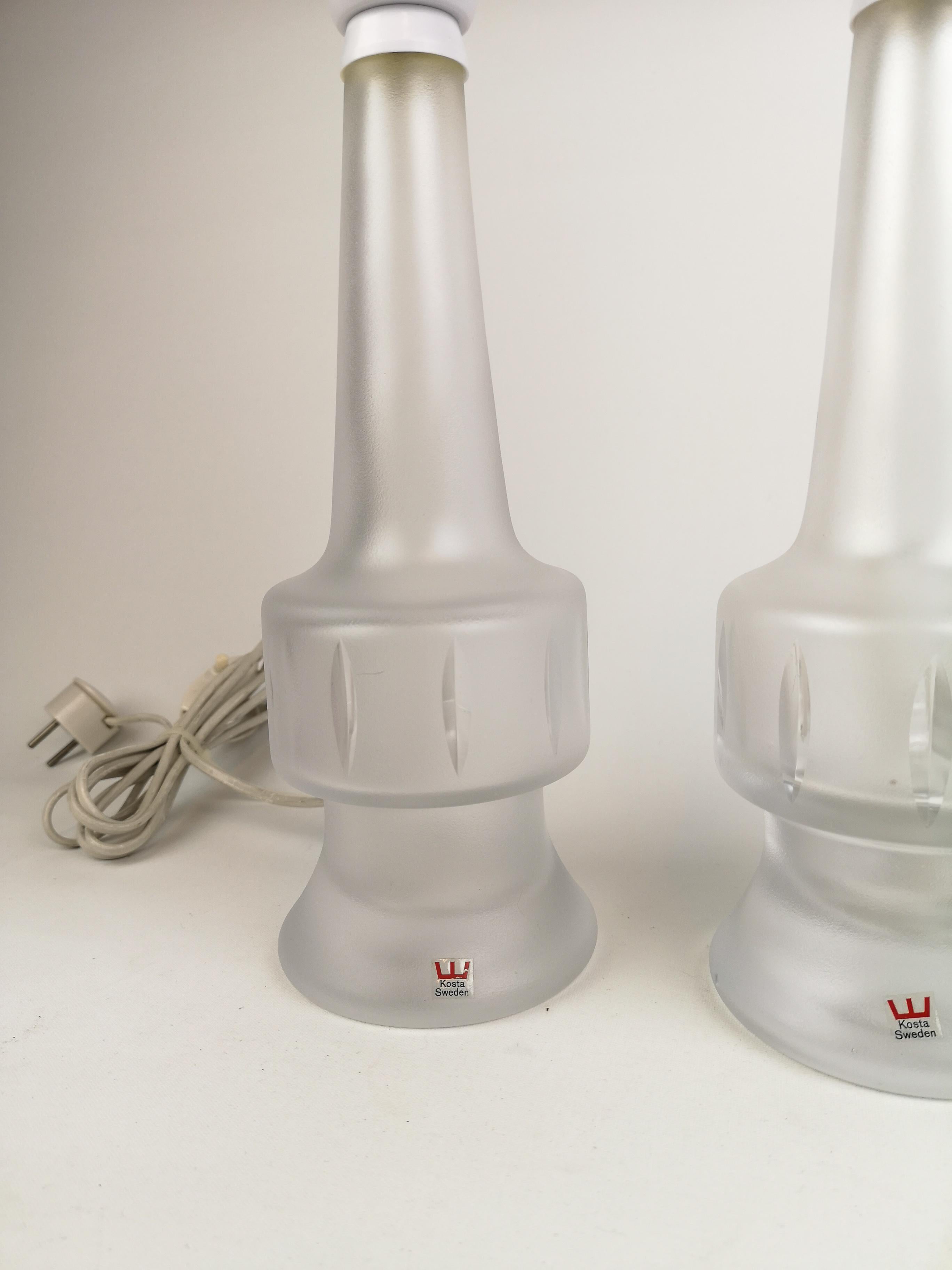 Cette paire de lampes de table en cristal plein a été fabriquée en Suède chez Kosta dans les années 1960. 

Ils sont tous deux en bon état de marche. Une avec une petite rayure.
 