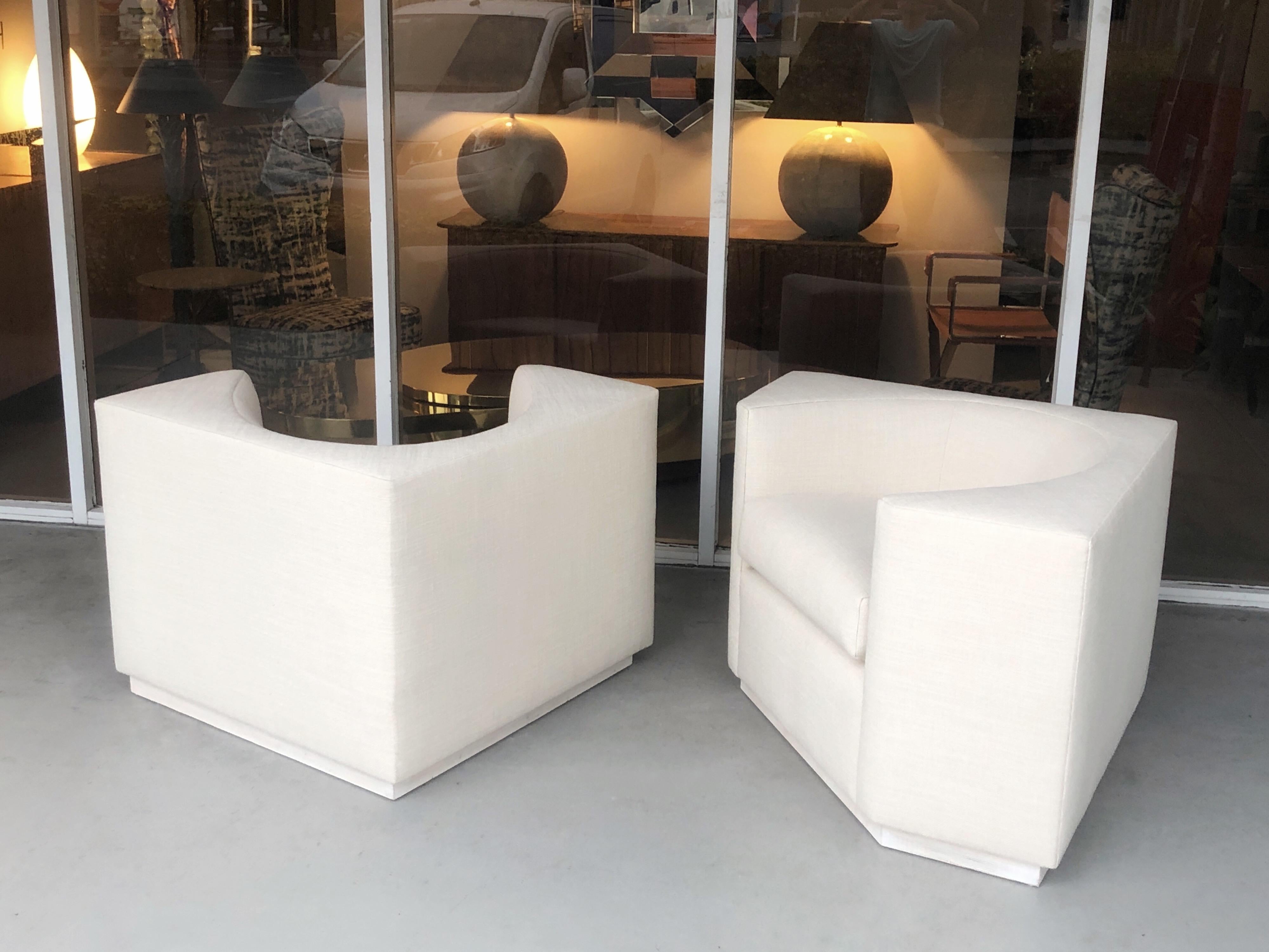 A modern pair of lounge chairs. Geometric design with and angular exterior and a rounded seating area. Very clean design.