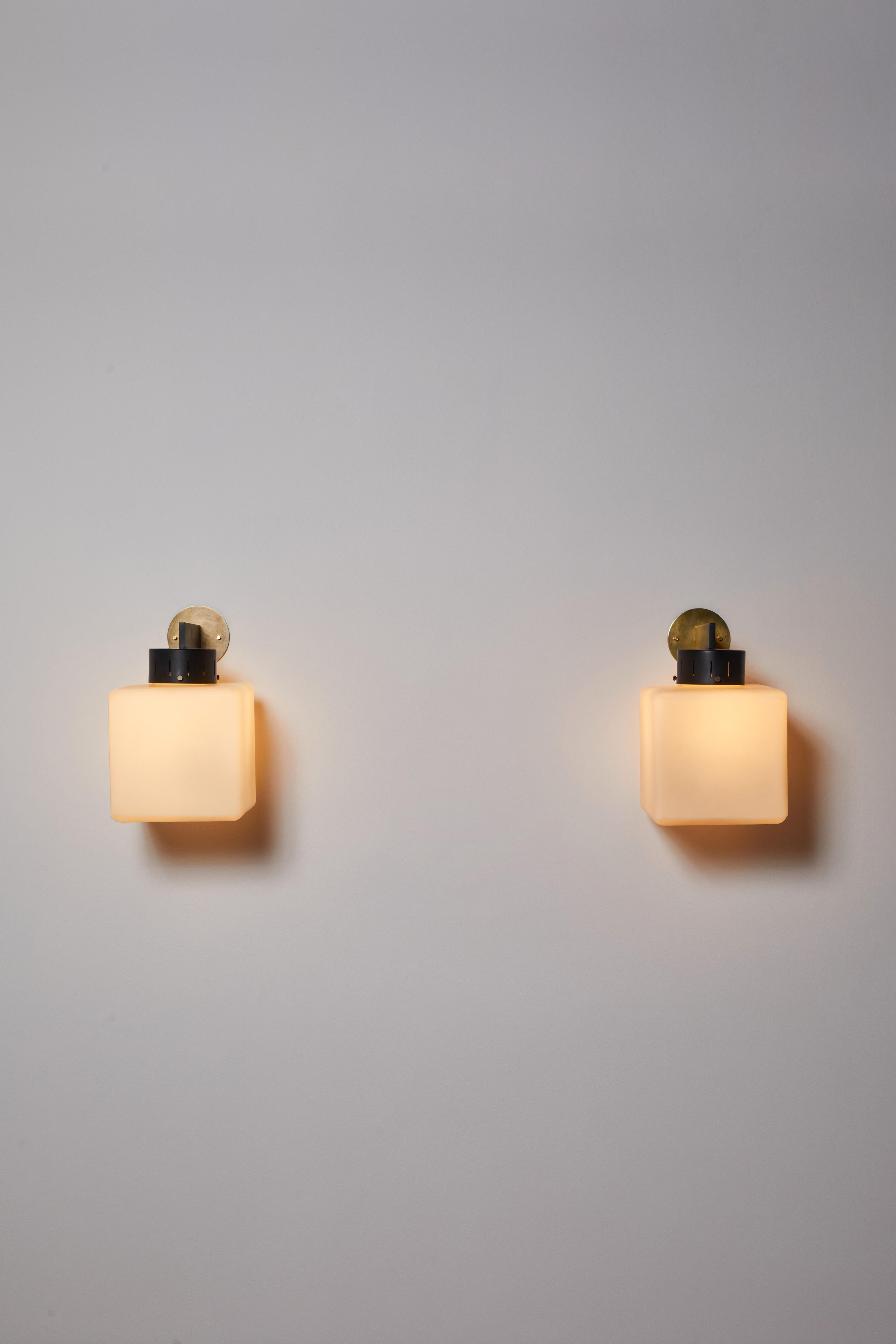 Pair of cube shaped sconces by Stilnovo. Manufactured in Italy, circa 1960s. Brushed satin glass, painted metal, brass. Custom brass backplates. Rewired for U.S. standards. Fully restored. Each fixture has one socket. We recommend one E27 25-60w