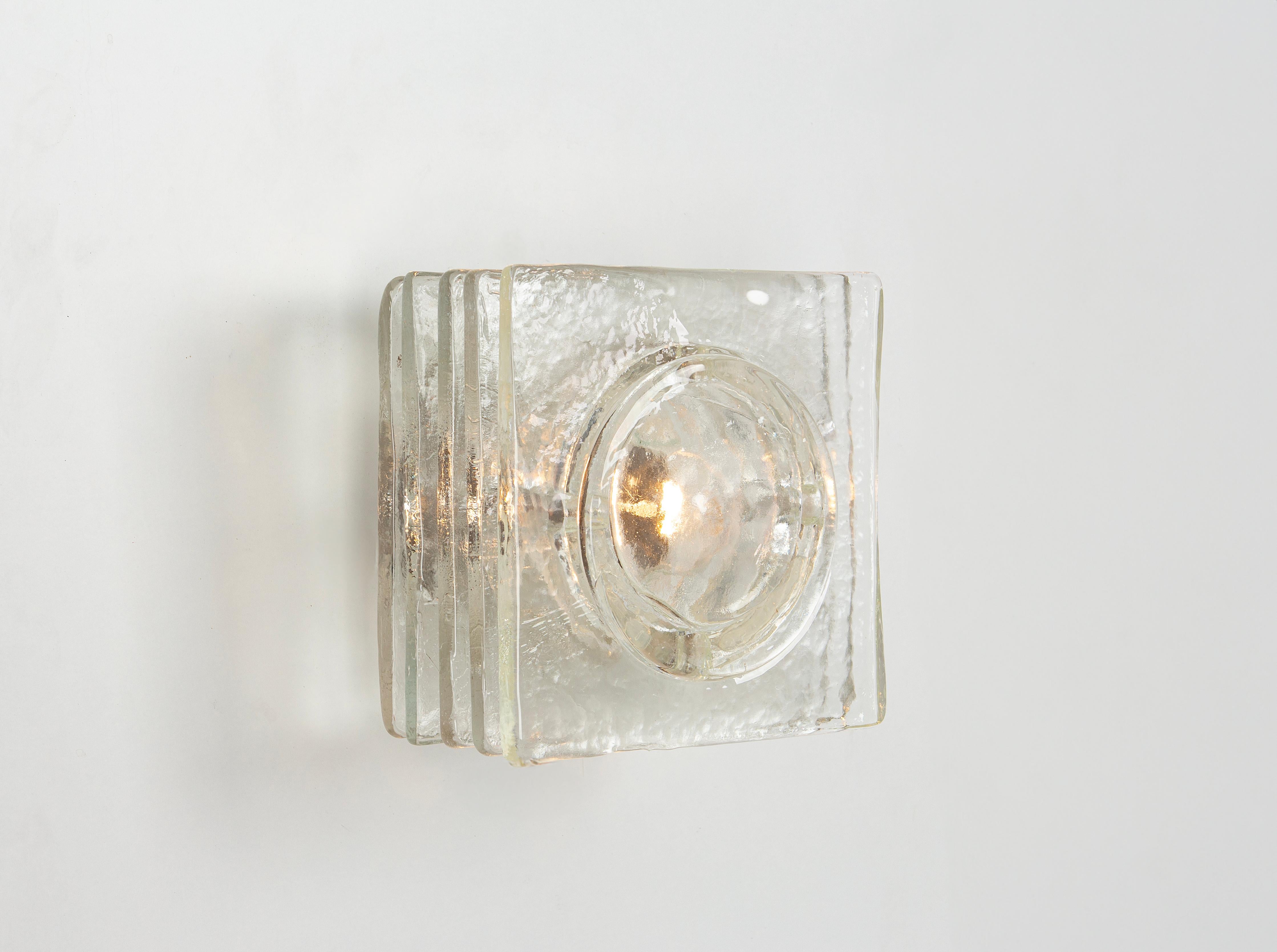 Pair of Cubic Mid-Century Wall Sconce in style of Poliarte, 1970s

It's composed of glass squares stacked together. The glass is clear but textured. Holds one standard socket ( E27) on a metal frame.
Sockets: 1 x E27 standard bulb.
Light bulbs are