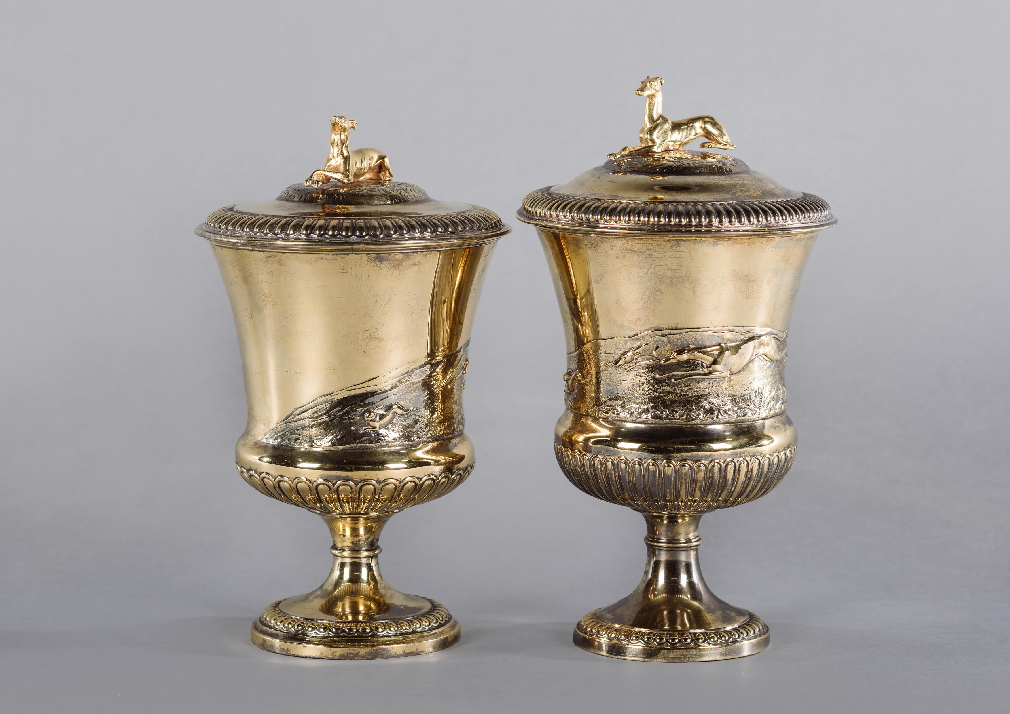 An unusual pair of George IV silver-gilt cup and covers by John Bridge for Rundell, Bridge & Rundell.

English, circa 1824-1826. 

Hallmarks for Rundell, Bridge & Rundell, London, 1824-1826. 

Each cup has a lobed circular foot, with a