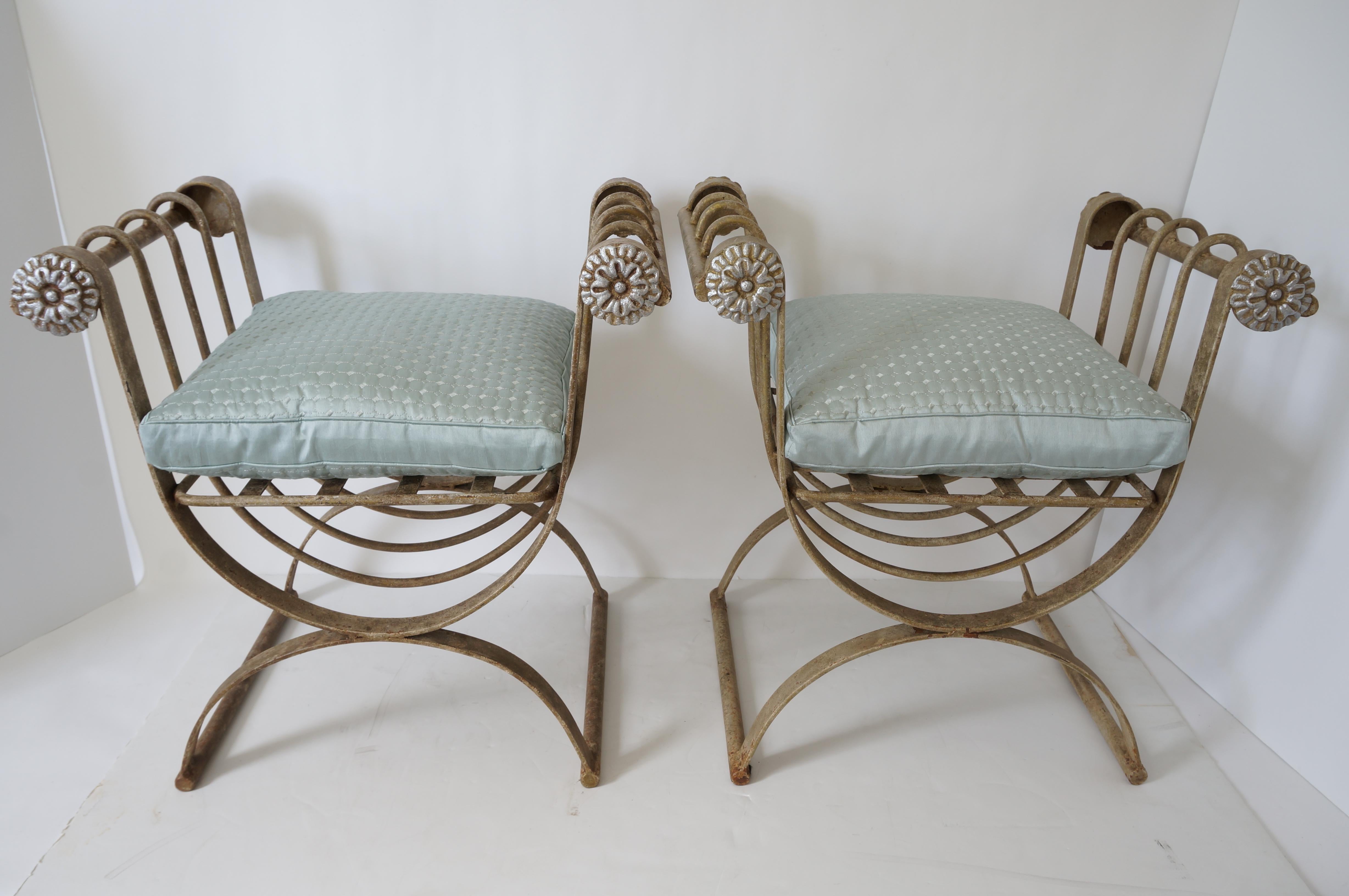 This stylish pair of iron curule-form benches have an antique painted beige/tan finish and the rosettes are a silver tone.

Note: Seat height without the cushion is 15.75