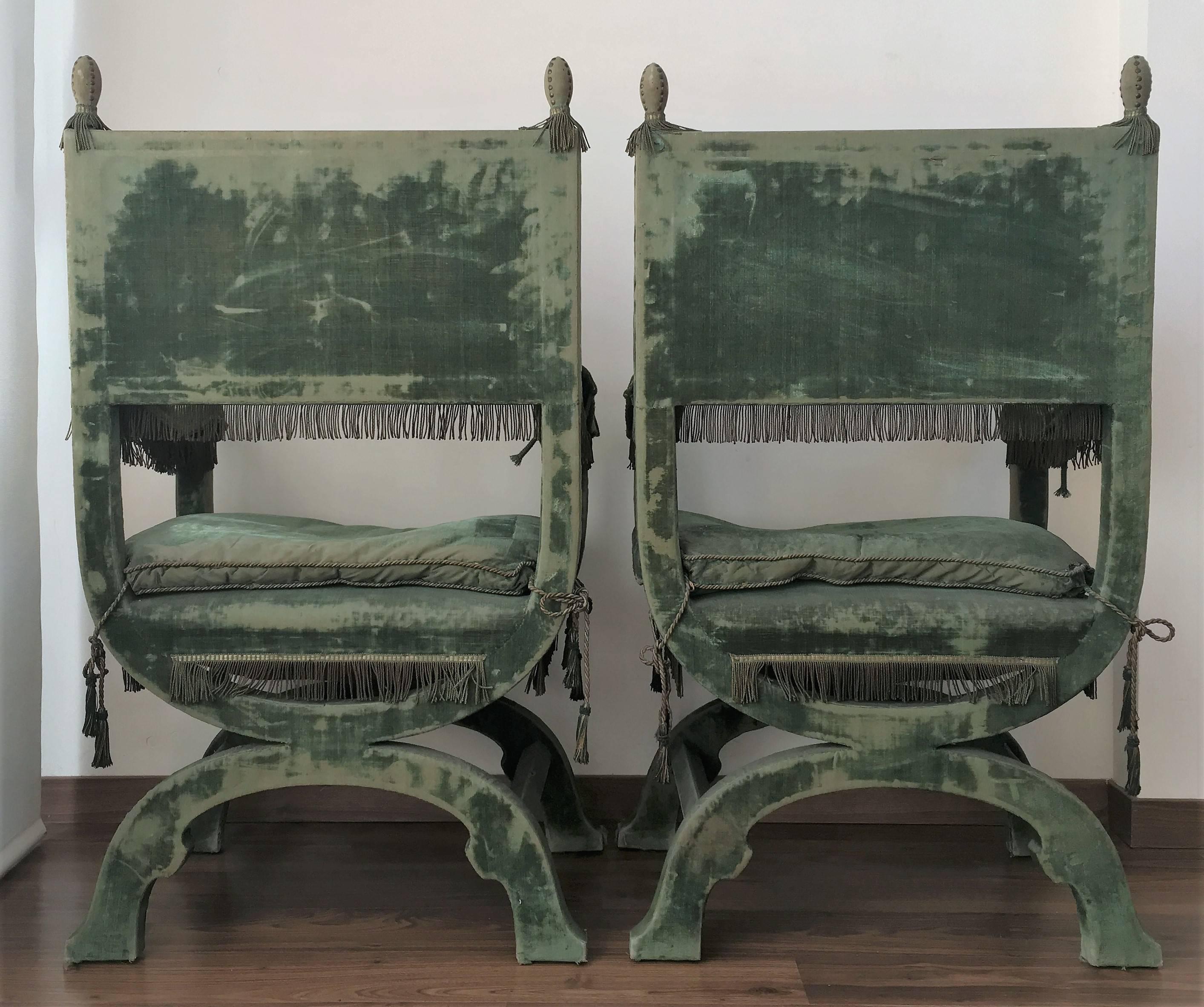 A charming and rare pair of 19th century walnut curule-form armchair, each with back, arms and seat cushion, on curved legs.
Upholstered in original worn green silk velvet with heraldic shield in each back.