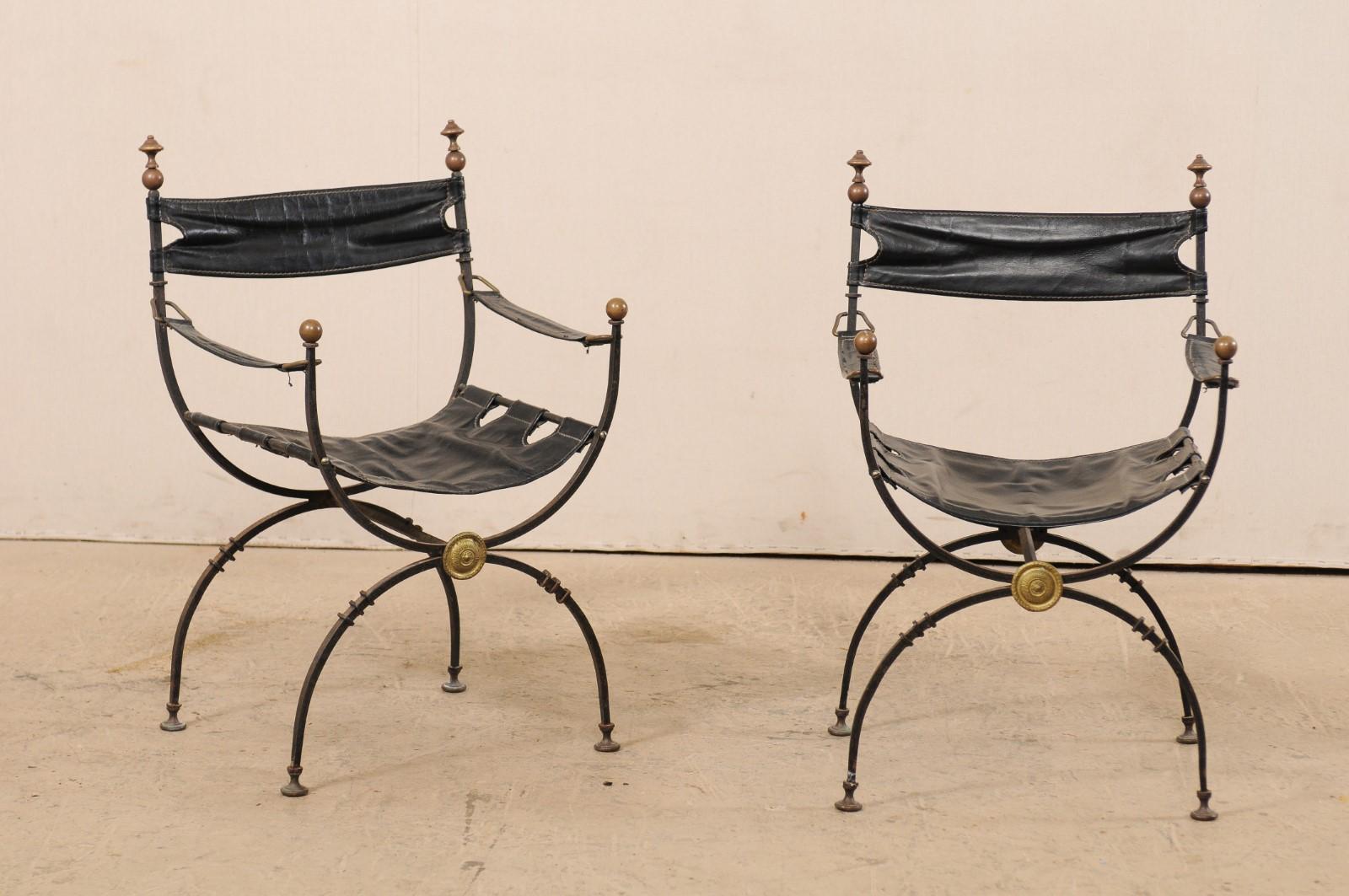 A pair of Italian curule Savonarola chairs with black leather from the early 20th century. This pair of antique Italian curule chairs, also commonly called Savonarola, which are defined by their signature semi-circular frames which connect where the