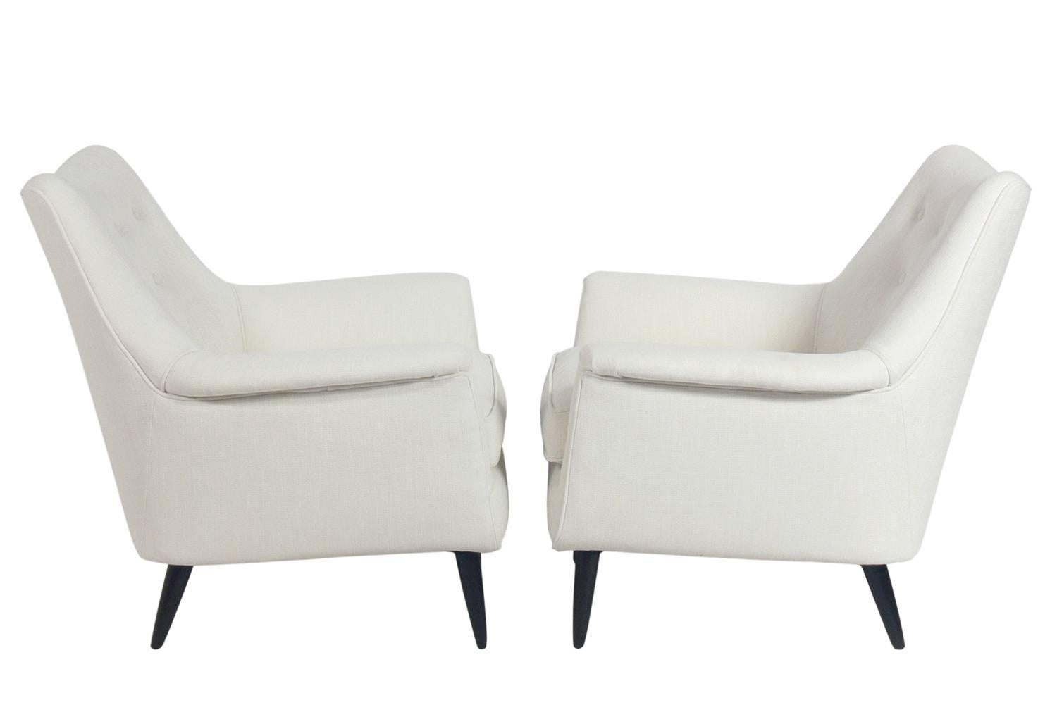 Pair of curvaceous Italian lounge chairs, Italy, circa 1950s. They have been completely restored in an ivory white color woven fabric with the wood legs refinished in an ultra-deep brown lacquer. The price noted below is for the pair of chairs.