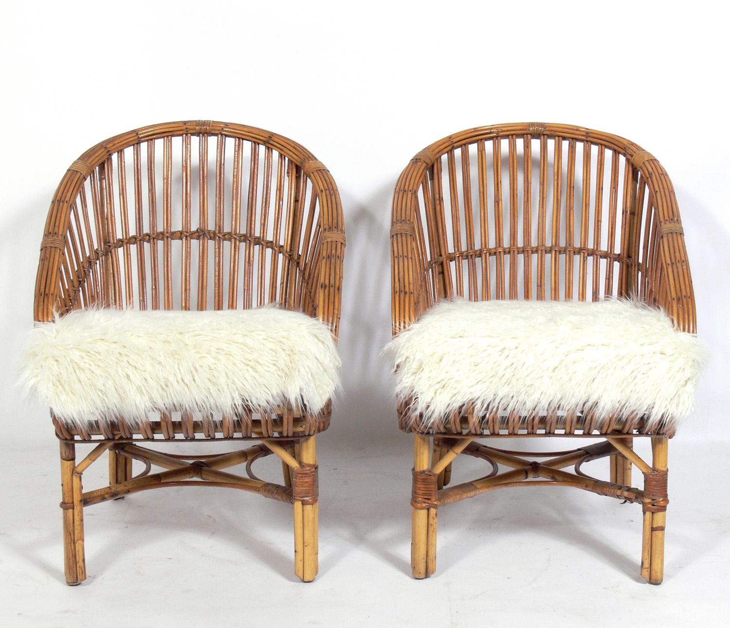 Pair of Curvaceous Rattan chairs, in the manner of Franco Albini, probably Italian, circa 1950s. They have been reupholstered in an ivory color herringbone upholstery and they include the faux sheepskin throws.