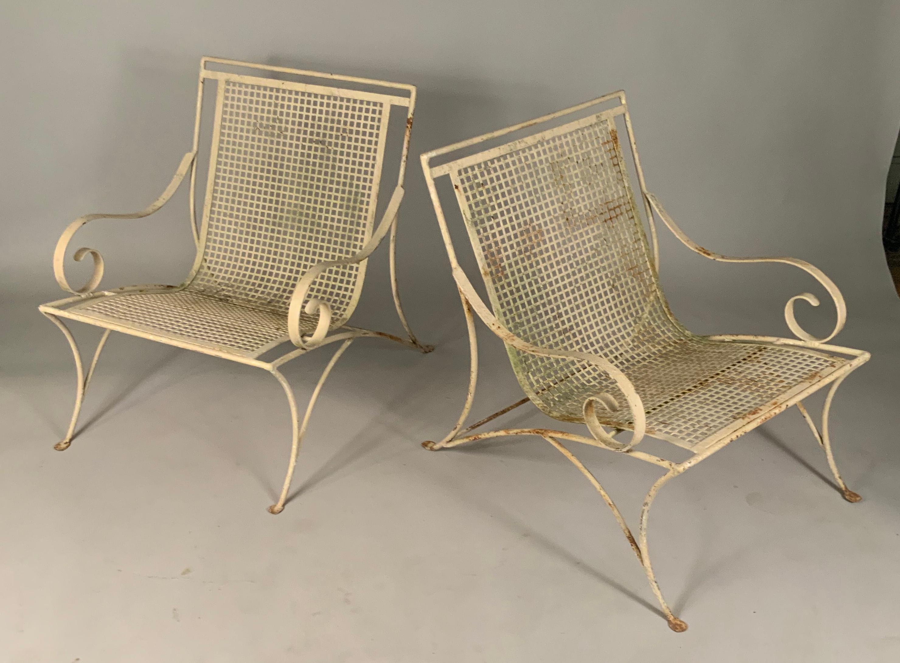 a very engaging pair of vintage 1960's wrought iron lounge chairs, with beautifully scrolled frames, and a grid pattern seat and back. great stylish design and very well made. the original finish is worn, but these could easily be stripped and