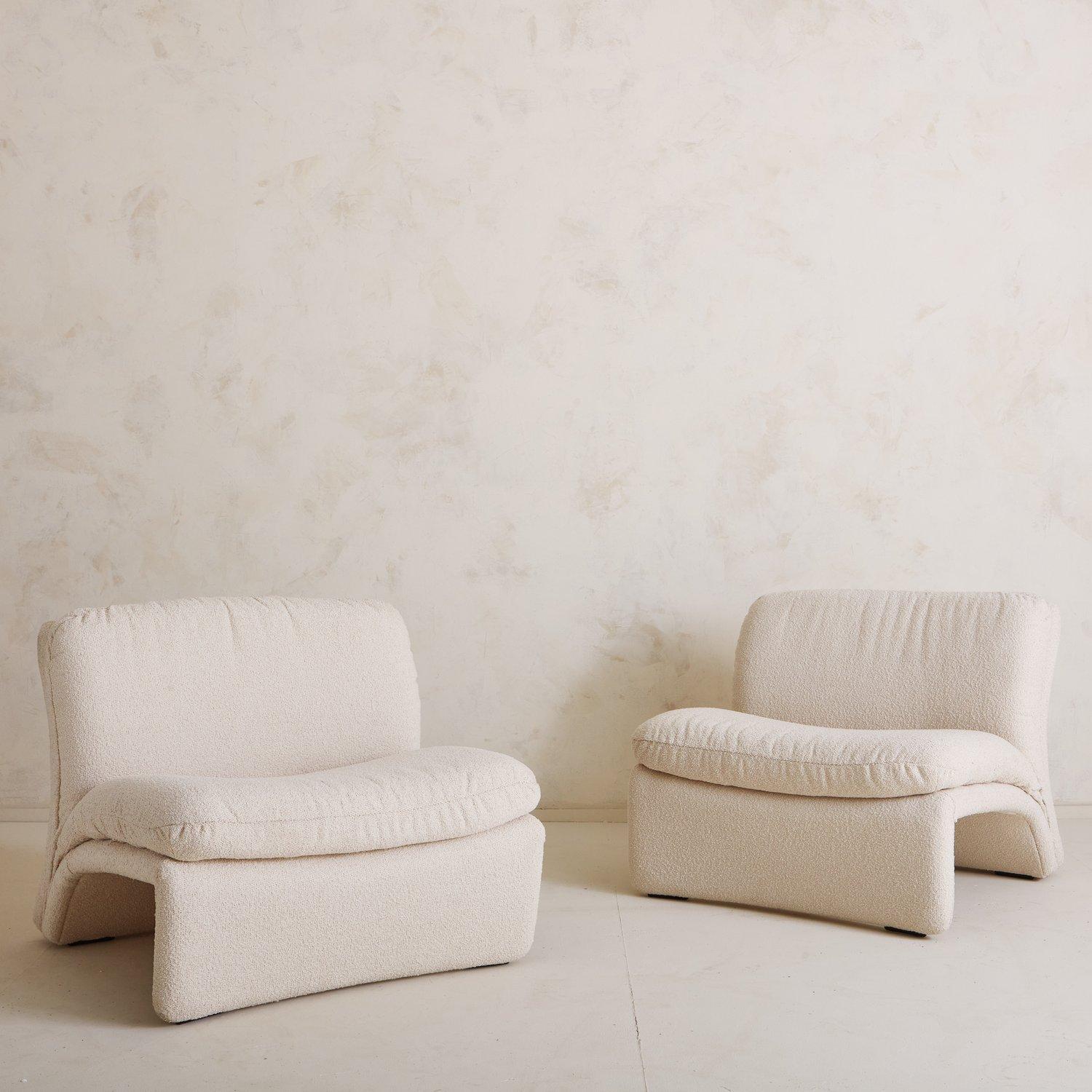 A pair of sculptural vintage lounge chairs upholstered in a textural ivory fabric. We love the dramatic curves on these statement chairs. Sourced in Italy, 20th Century.
