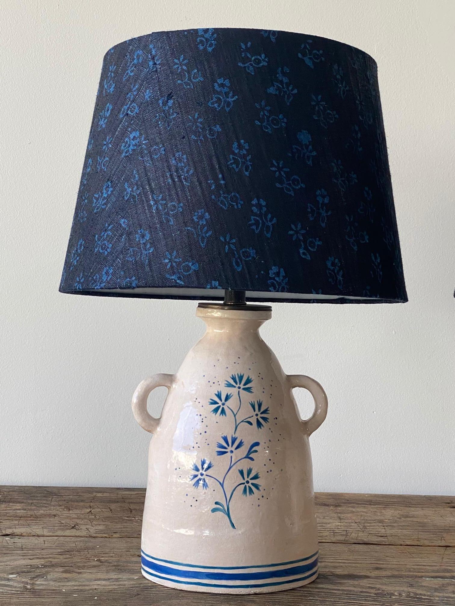Beautiful pair of custom ceramic table lamps by Alix Soubiran. The lamps are hand painted, custom navy and blue shade provided, the shade is made from vintage French fabric. The lamps come with brown twist cord. The lamp base measures 7