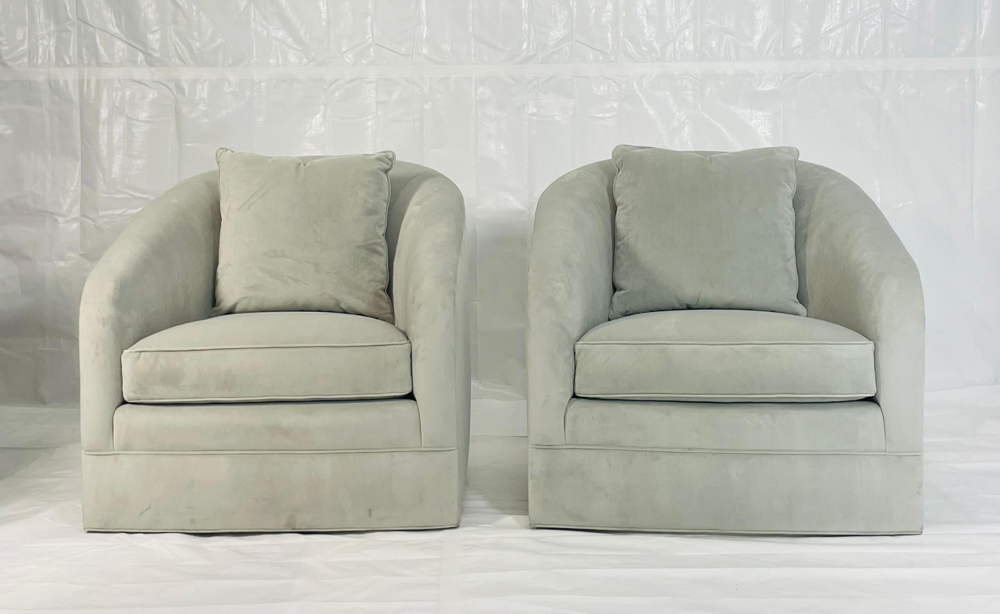 Elegant pair of barrel-back swivel lounge chairs designed and manufactured by Custom Craft Upholsterers, Inc. in Los Angeles, California. Each chair features smooth sculptural lines, fully upholstered bases, and generous seat and back cushions for a