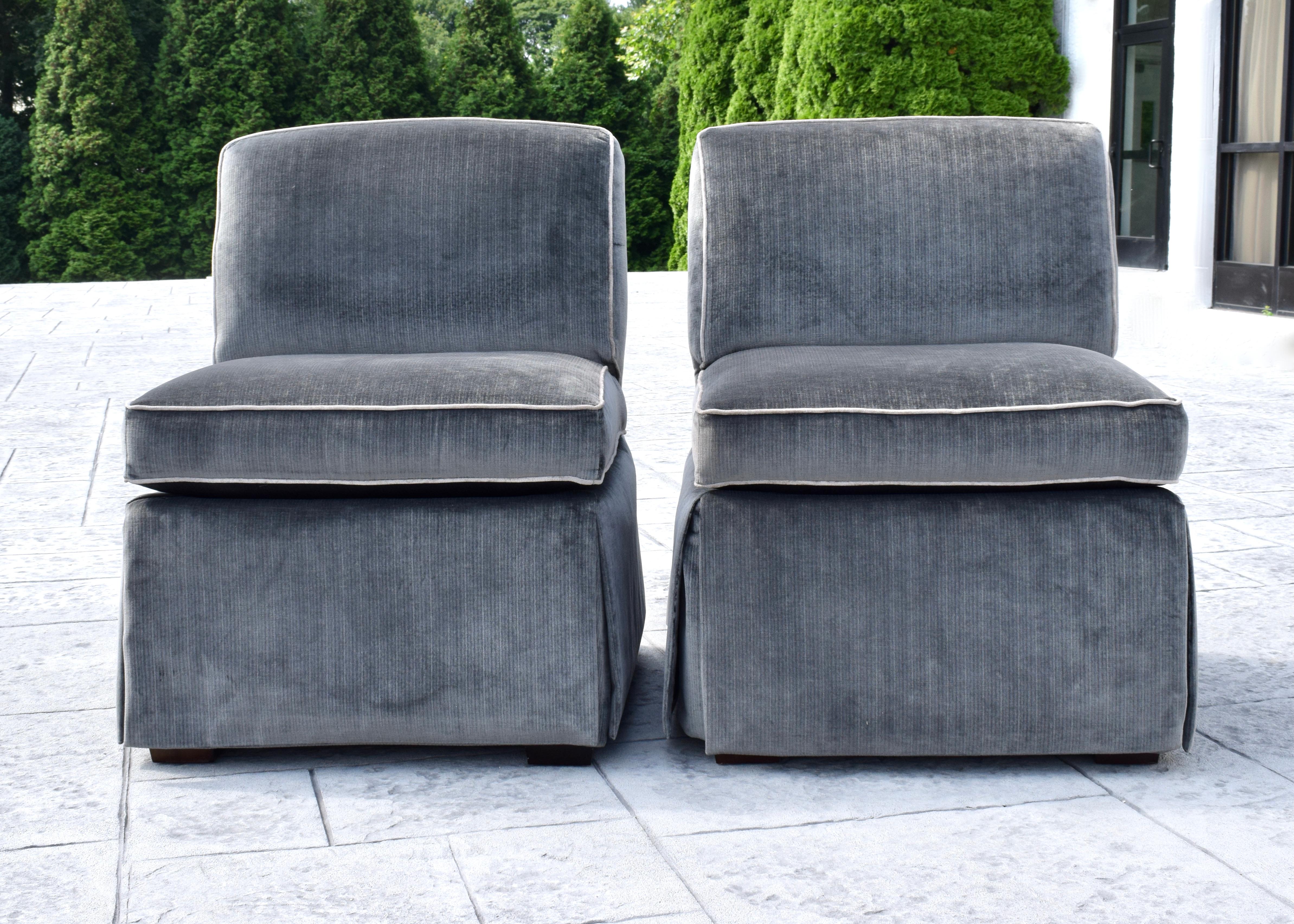 A pair of custom made Billy Baldwin style slipper chairs upholstered in rich charcoal velvet boasting Billy Baldwin signature back notched seat detailing with seat to floor length box pleat skirt. Beautifully constructed with nice weight. Seats: