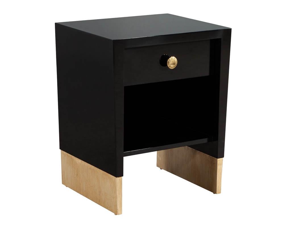 Pair of custom black lacquered nightstand end tables. Handcrafted and custom made by the artisans at Carrocel. Featuring tapered edge design with gold leafed legs. Completed in a hand polished black lacquered finish with beautiful round brass