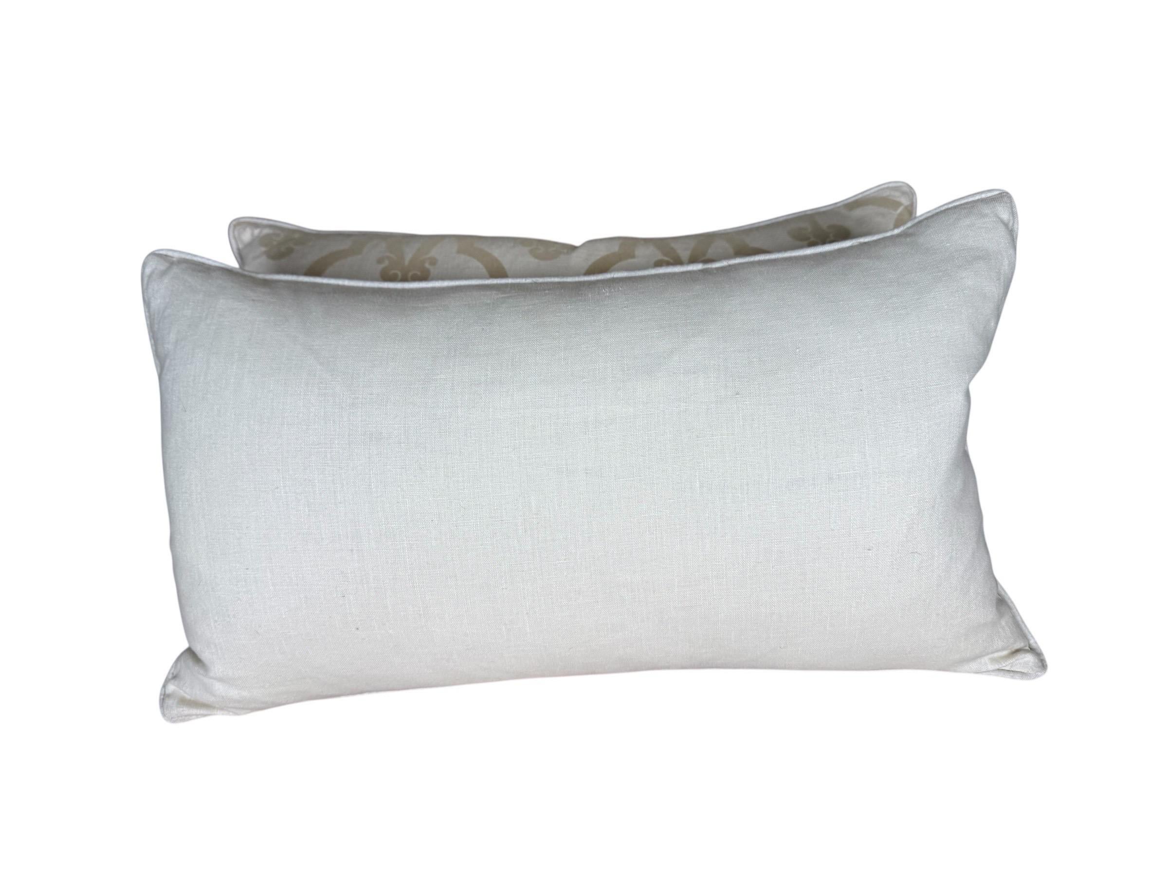 Una sofisticata coppia di cuscini decorativi personalizzati, realizzati in lino avorio chiaro e arricchiti da un tessuto di velluto tagliato in una morbida tonalità beige-oro. Il velluto presenta un elegante motivo a scorrimento di ispirazione