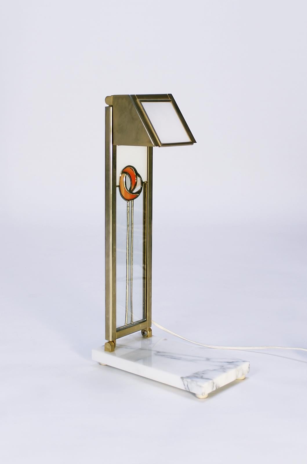 This unique vintage desk lamp is inspired by the Glasgow Art School and features Charles Rennie Mackintosh design elements.
It can be adjustable in several directions. Opal glass and brass plates on faux marble basis. Original wiring. It takes a