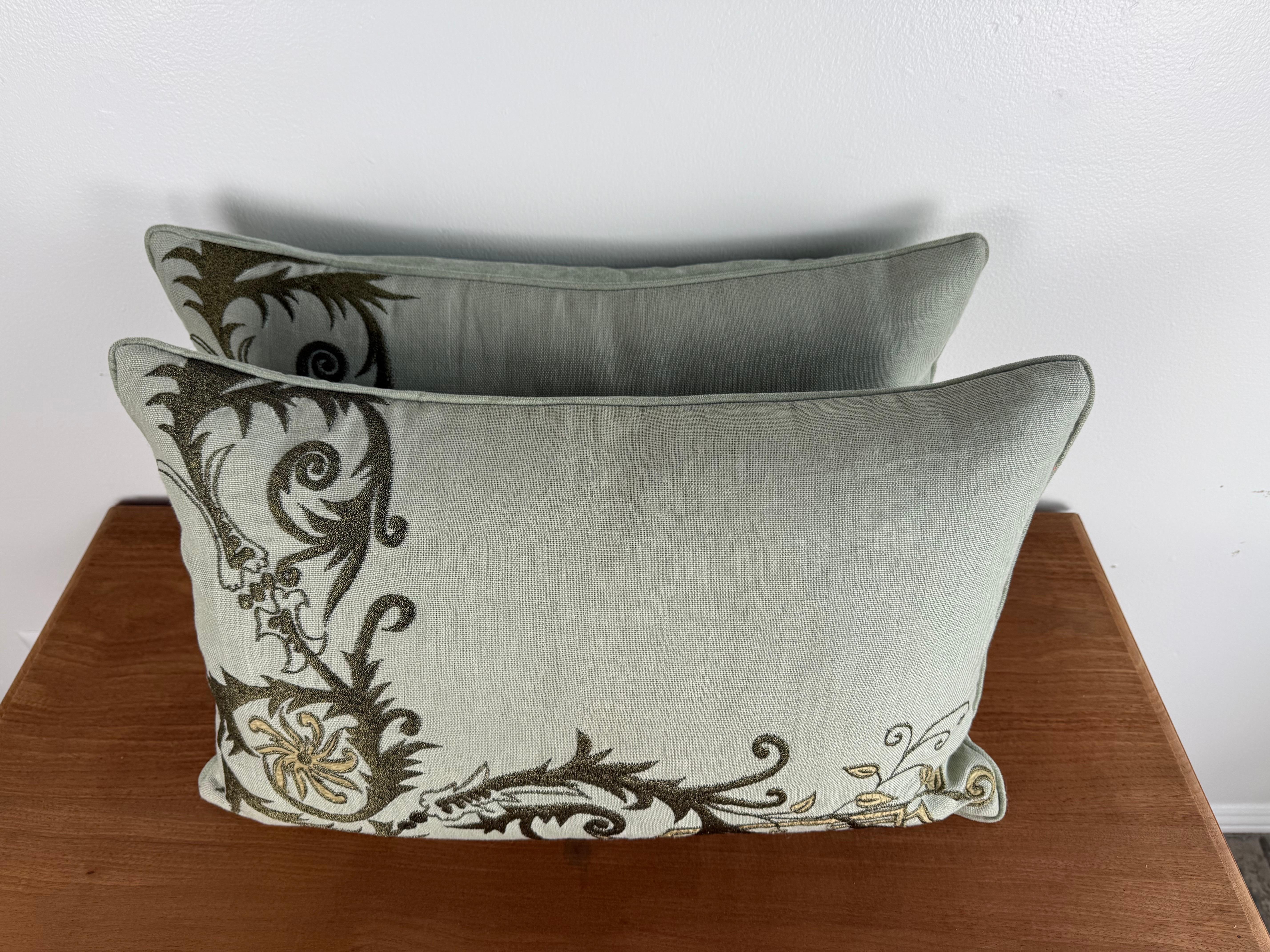 Una bellissima coppia di cuscini dal design personalizzato realizzati con il lussuoso tessuto ricamato di Embroidery Palace. L'intricata fantasia presenta motivi botanici a scorrimento in tonalità oliva, oro e neutre, creando un sofisticato gioco di