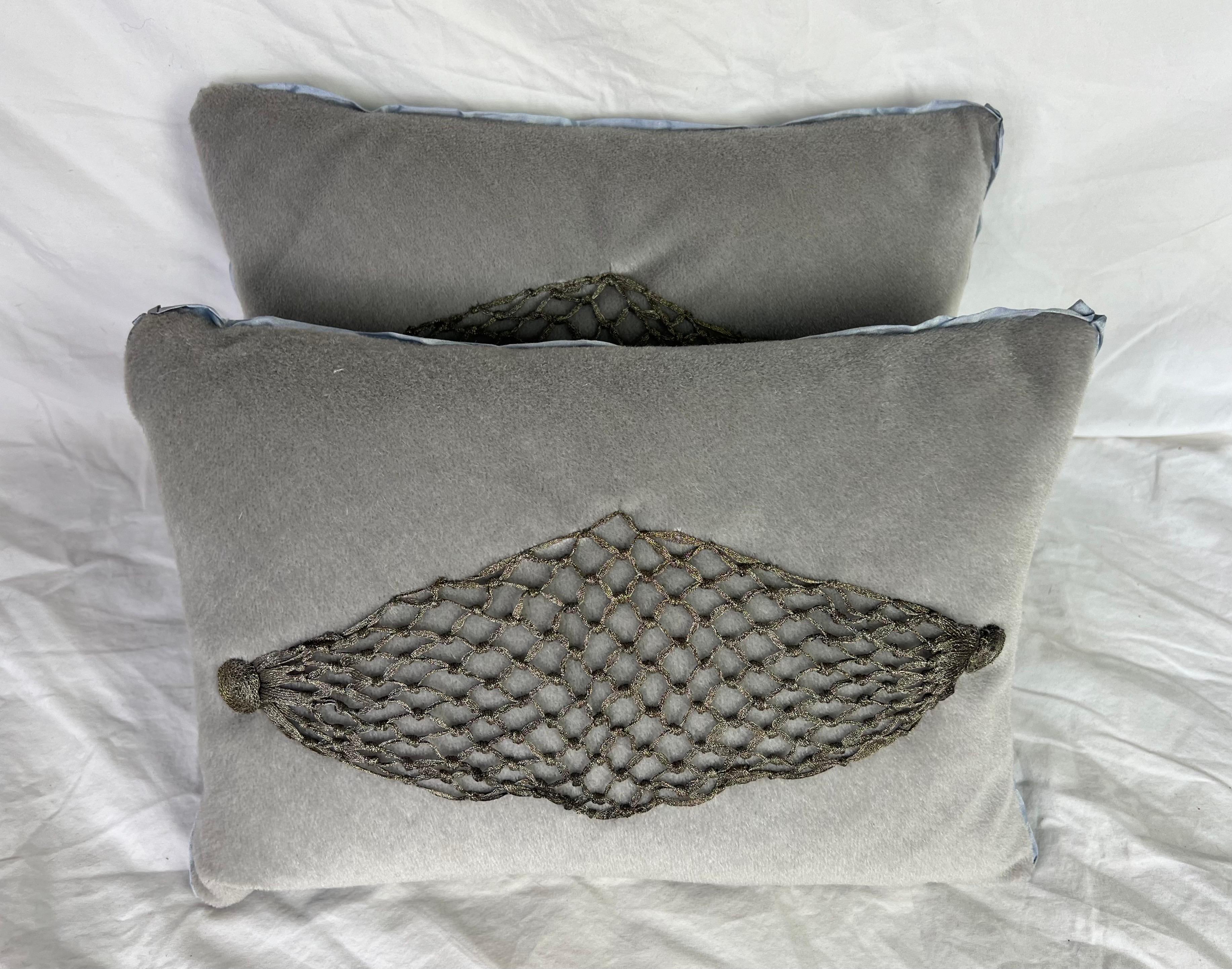 Coppia di cuscini personalizzati di piccole dimensioni che combinano pizzo metallico e mohair grigio.  Il pizzo metallico del XIX secolo viene applicato al mohair per creare cuscini unici nel loro genere. Inserti in piuma, chiusure a zip nascoste.