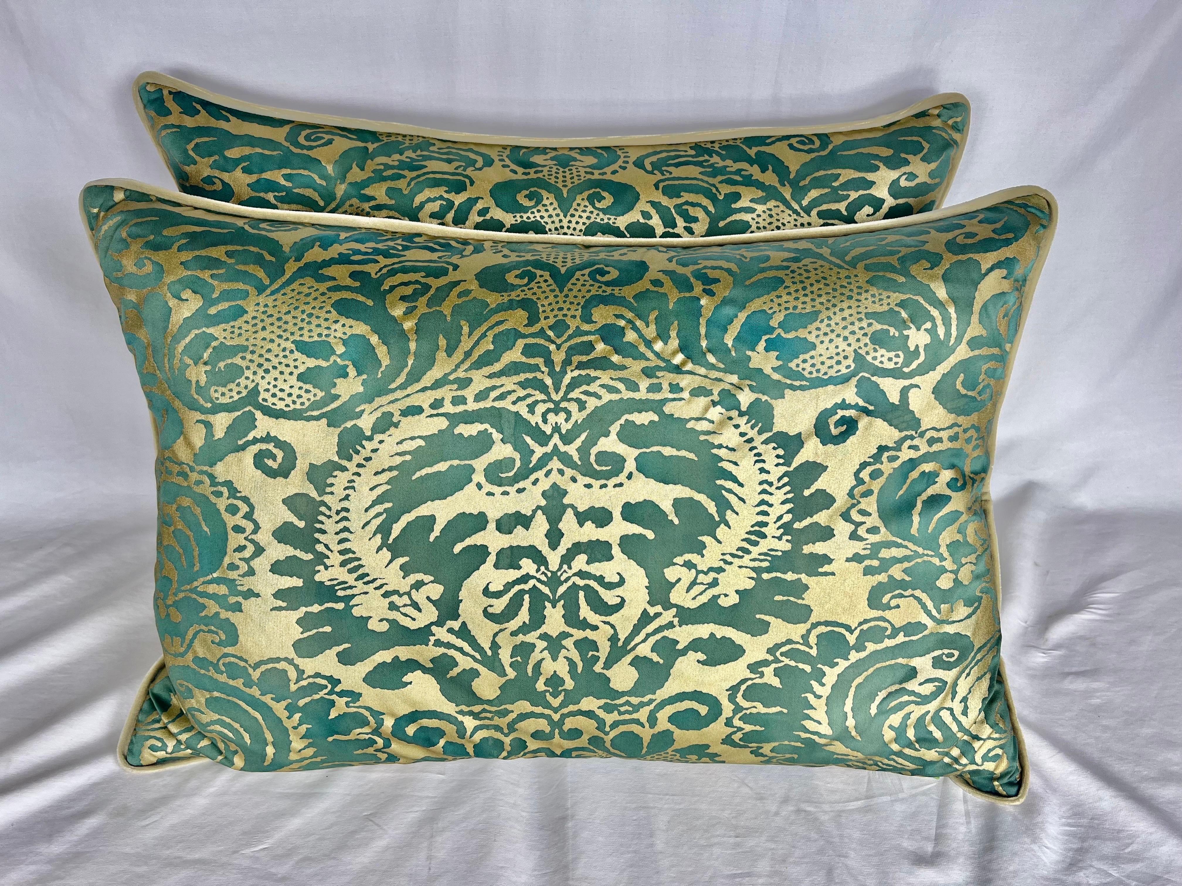 Pair of custom pillows made with dark green and metallic gold Fortuny style fronts and cream velvet backs with self cording. Down insert and zipper closures.