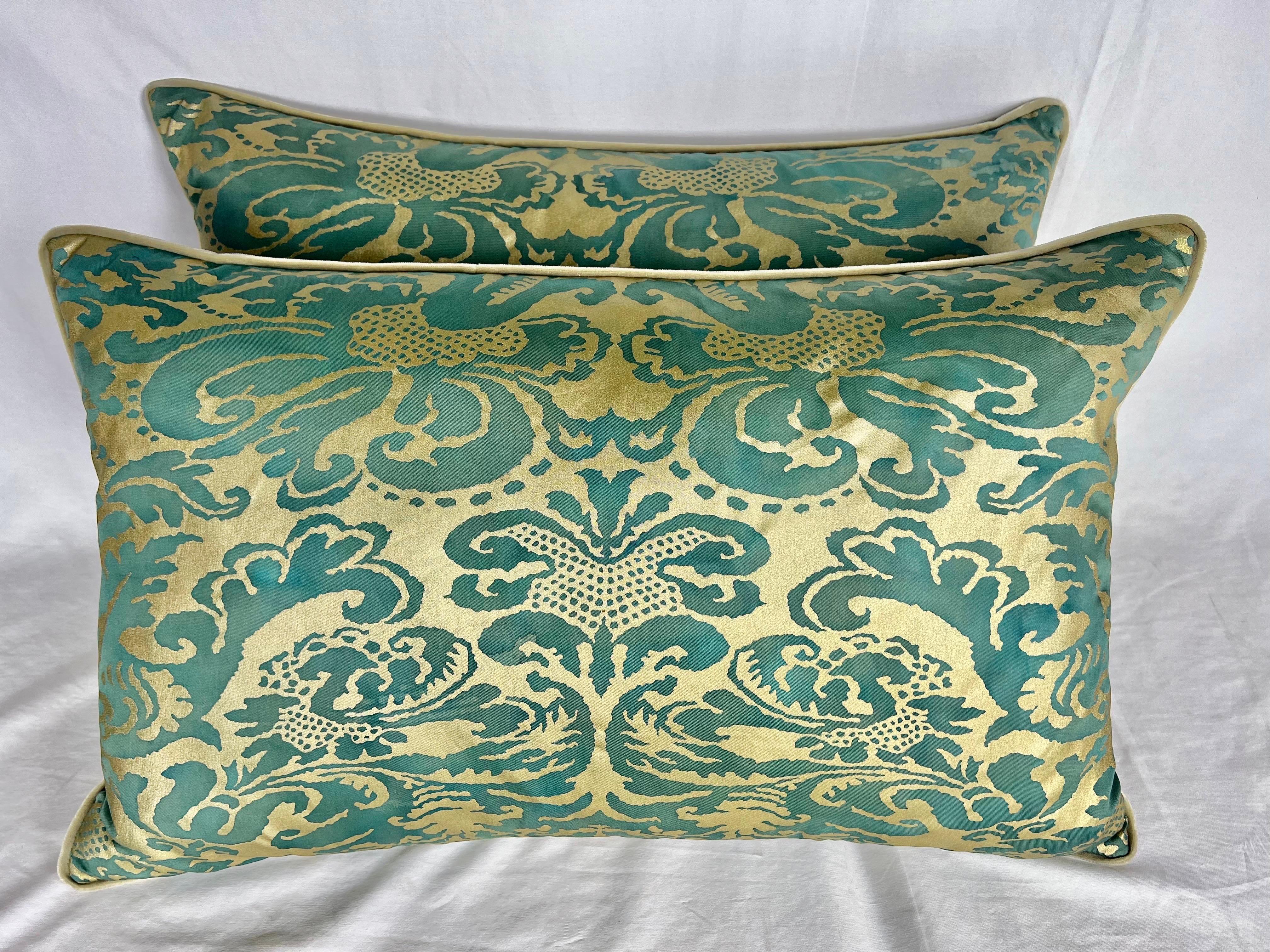 Pair of Italian Fortuny Pillows in a teal green & metallic gold coloration. There is a neutral cream color on the backs with a self cord detail. Down insert.