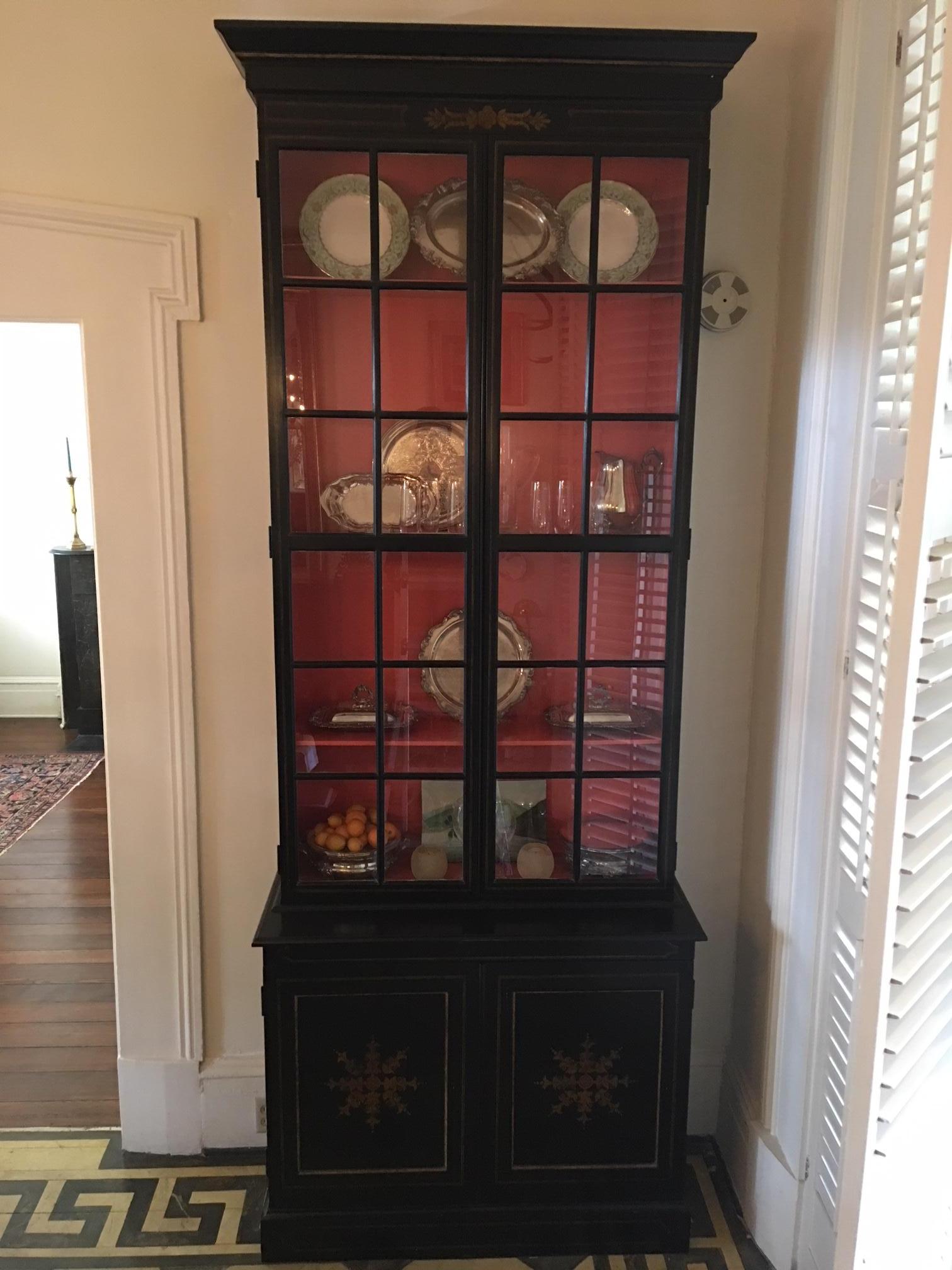 Pair of custom made ebony display cabinets with gold leaf detailing and glass shelves by John Rosselli, Mid-20th century. Lower compartment with shelving storage.  The apron where the cabinets open is 43.5