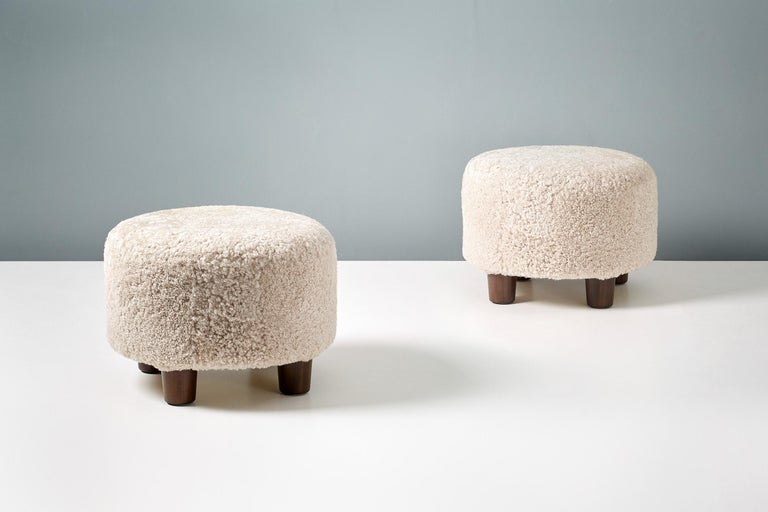 A pair of round custom made shearling ottomans on hardwood base with stained beech legs. The foam body is covered in premium, tufted Australian shearling. 

These items are made to order in our London workshop, multiple pieces are available by