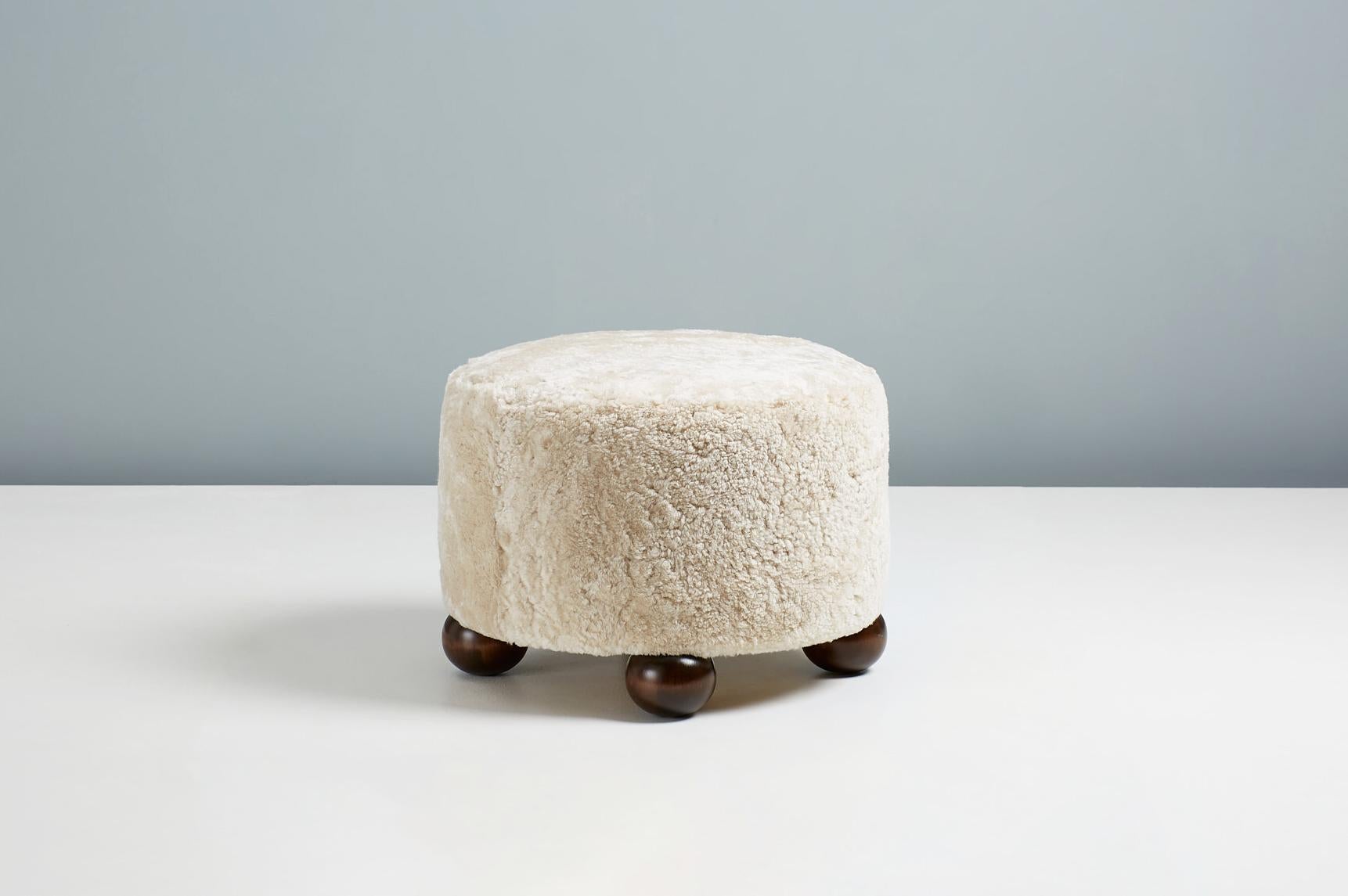 Dagmar design - round ottoman.

Custom-made ottomans developed & produced at our workshops in London using the highest quality materials. These examples are upholstered in Moonlight sheepskin with stained and polished tulipwood ball feet. This