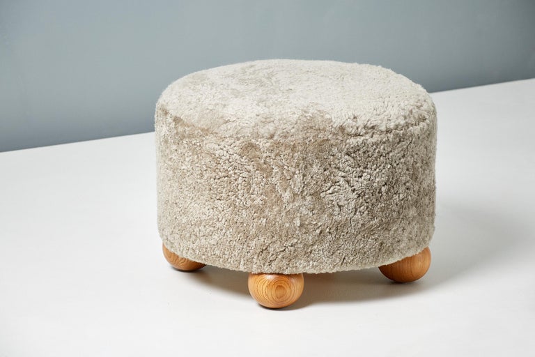 Custom-made ottomans developed & produced at our workshops in London using the highest quality materials. These examples are upholstered in a warm grey sheepskin and feature oiled oak ball feet.
 
