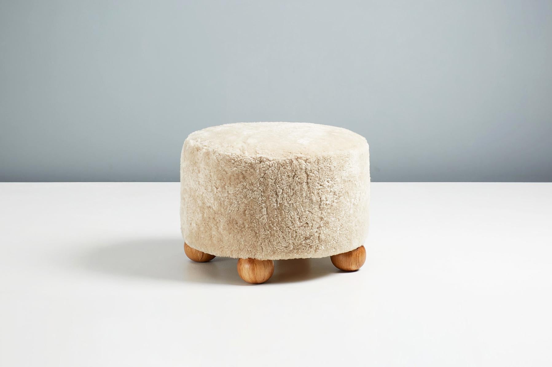 Cuir de mouton Paire d'ottomans ronds fabriqués sur mesure en peau de mouton avec pieds à boule en chêne en vente