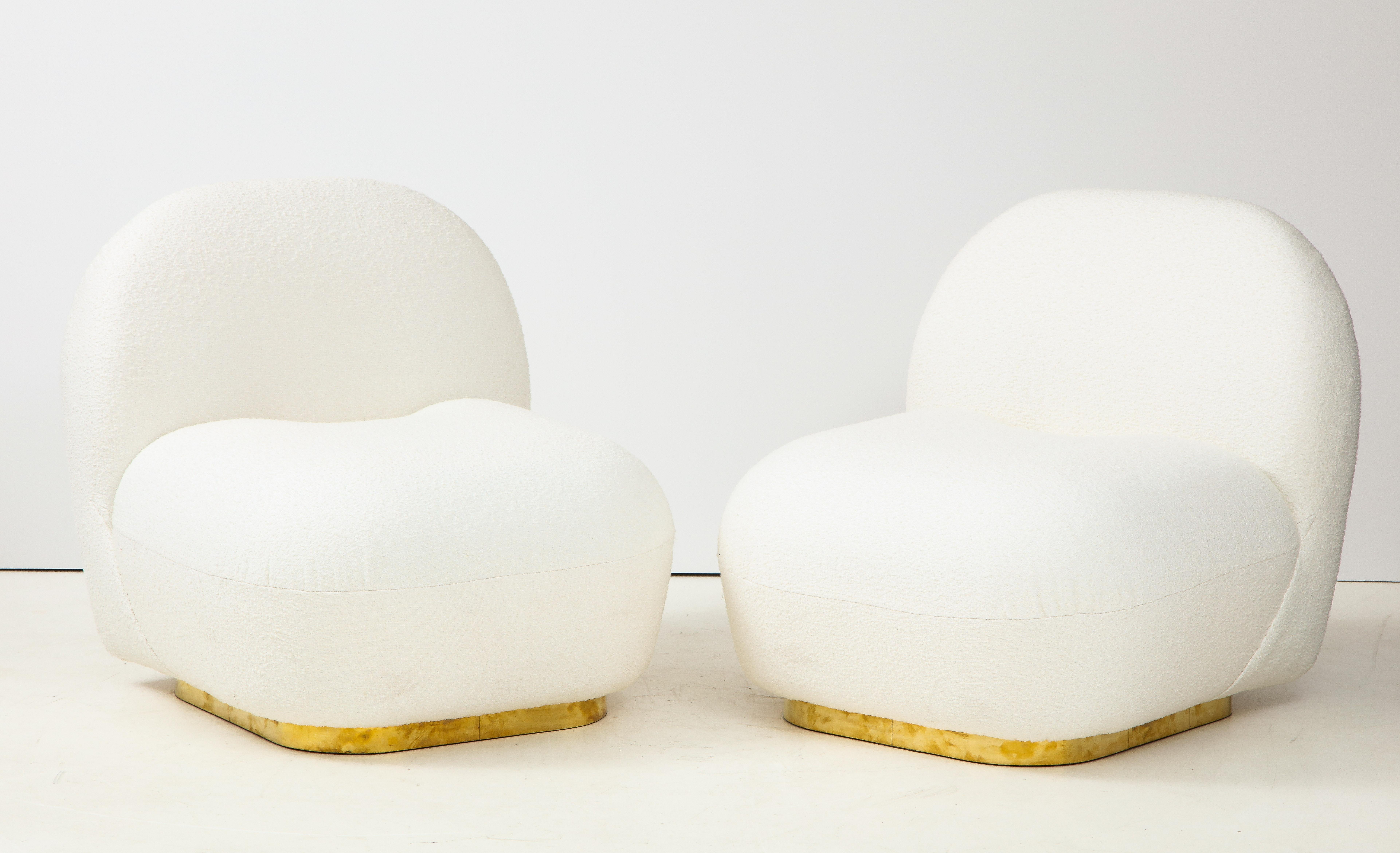 Pair of ivory bouclé sculptural lounge or slipper chairs custom made in Florence, Italy. Superb craftsmanship and design lines. With modern rounded padded back and seats, these slipper chairs are extremely comfortable and sit atop a polished brass