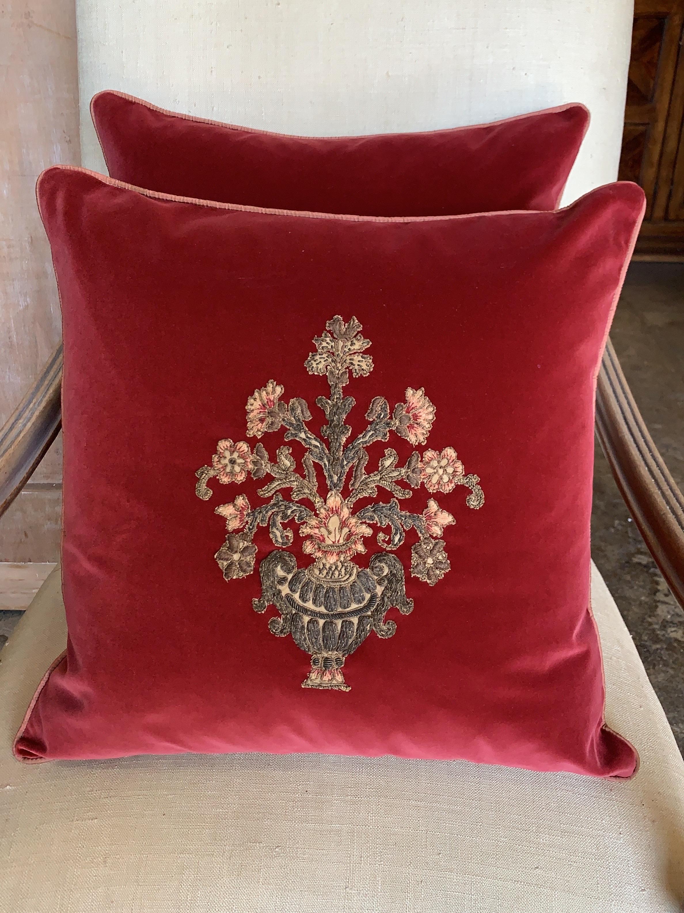 Pair of custom pillows with 19th century metallic and chenille floral appliques sewn on contemporary vibrant colored dark pink velvet background fronts and soft colored pink silk backs. Self cord detail. Down and feather inserts. 20” x 20”.