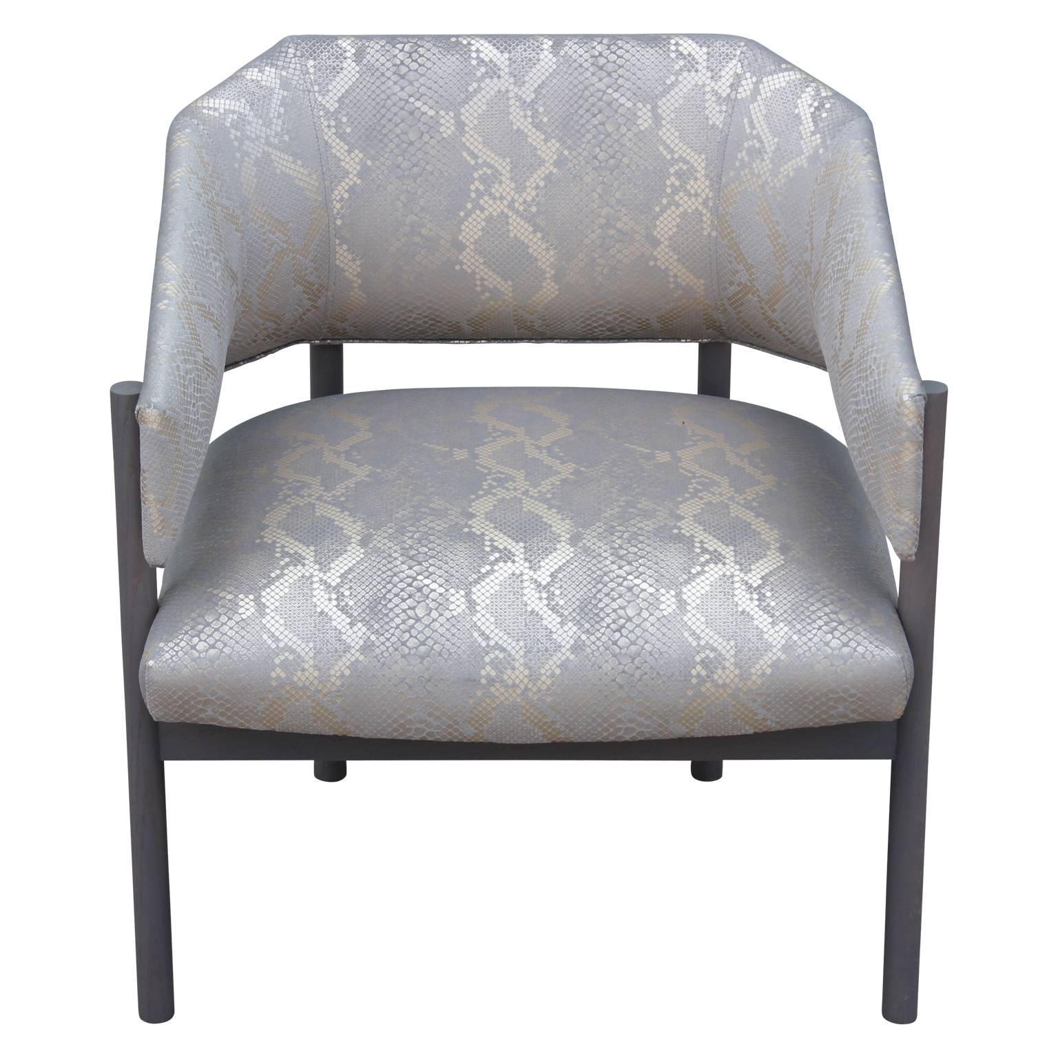 These wonderful modern sculptural lounge chairs are custom-made. These particular models are finished in a wonderful opaque stain and reupholstered in a shiny gold and gray python fabric. If you wish you have these made in any finish or COM. These