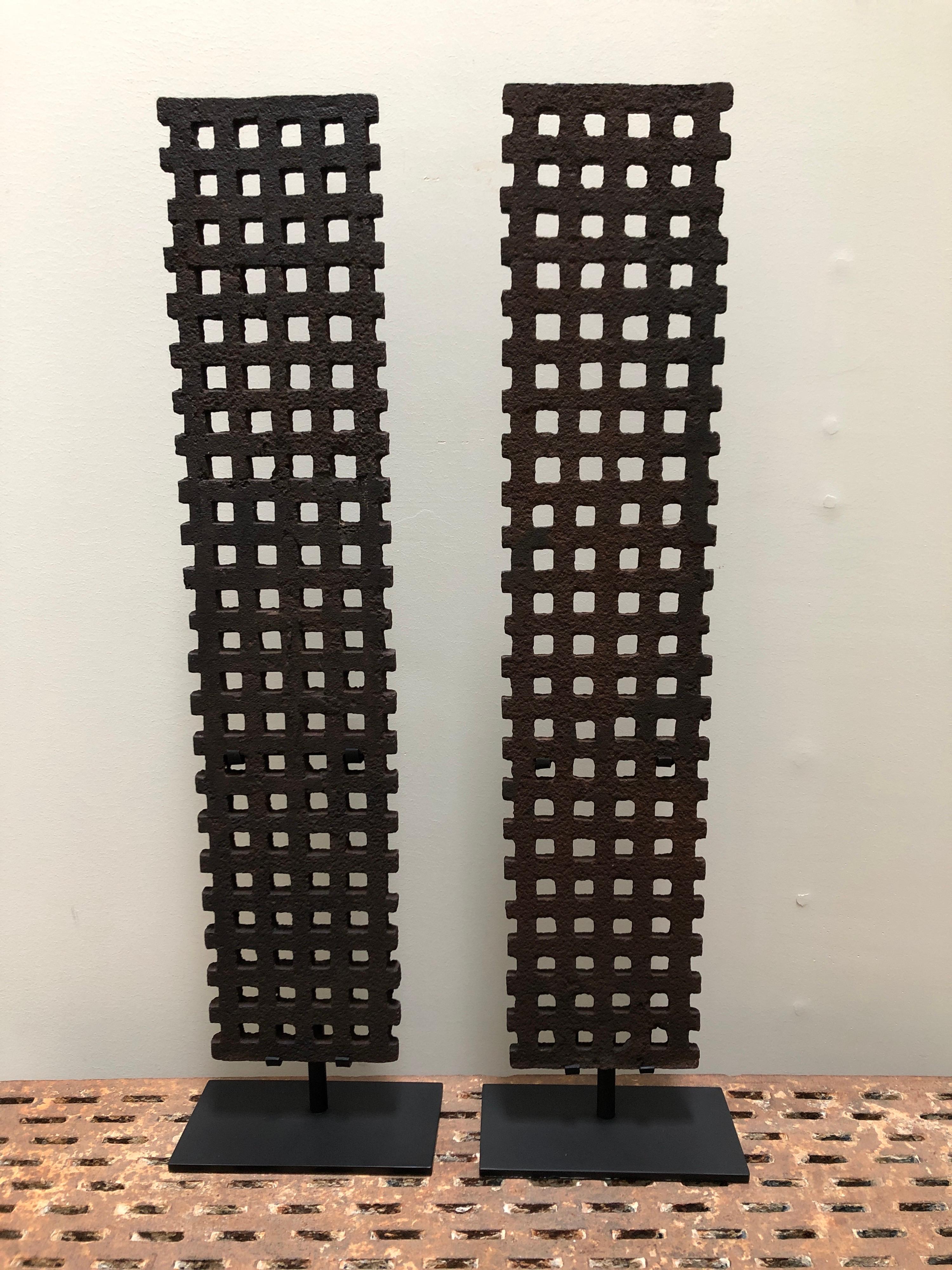 A pair of antique late 19th century cast iron grates from Philadelphia. Mounted on custom made steel stands that hide the supporting brackets. Great original color and textured surface from exposure. They measure 30 1/2
