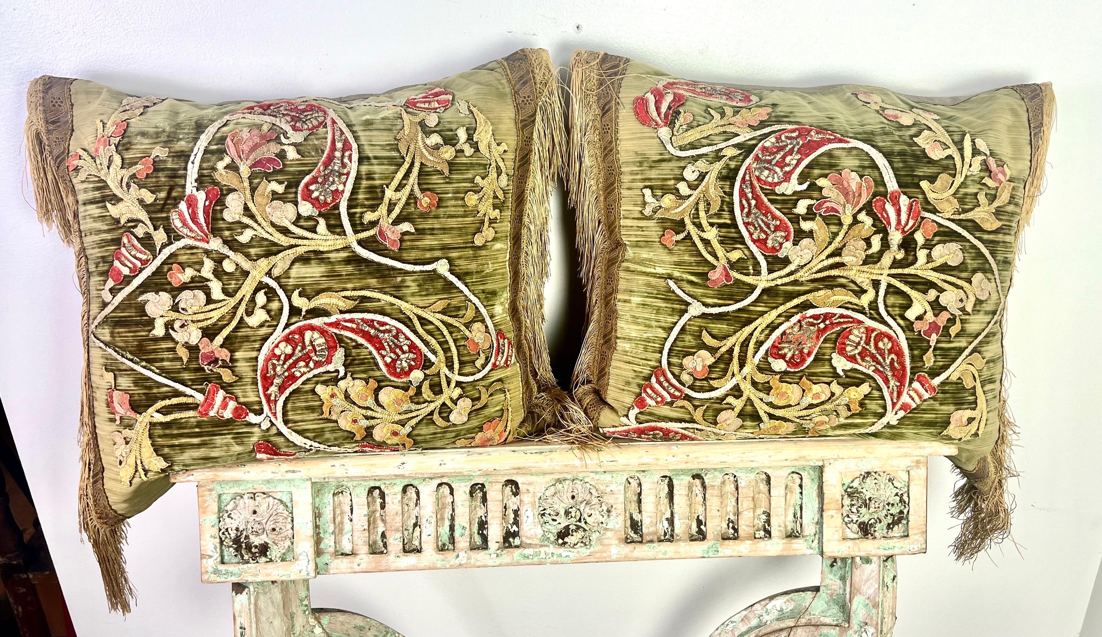 Une paire de coussins uniques et complexes, mêlant des éléments de différents siècles.  La combinaison de velours italien appliqué du XVIIIe siècle et de rubans métalliques dorés et de garnitures en soie du XIXe siècle crée une esthétique