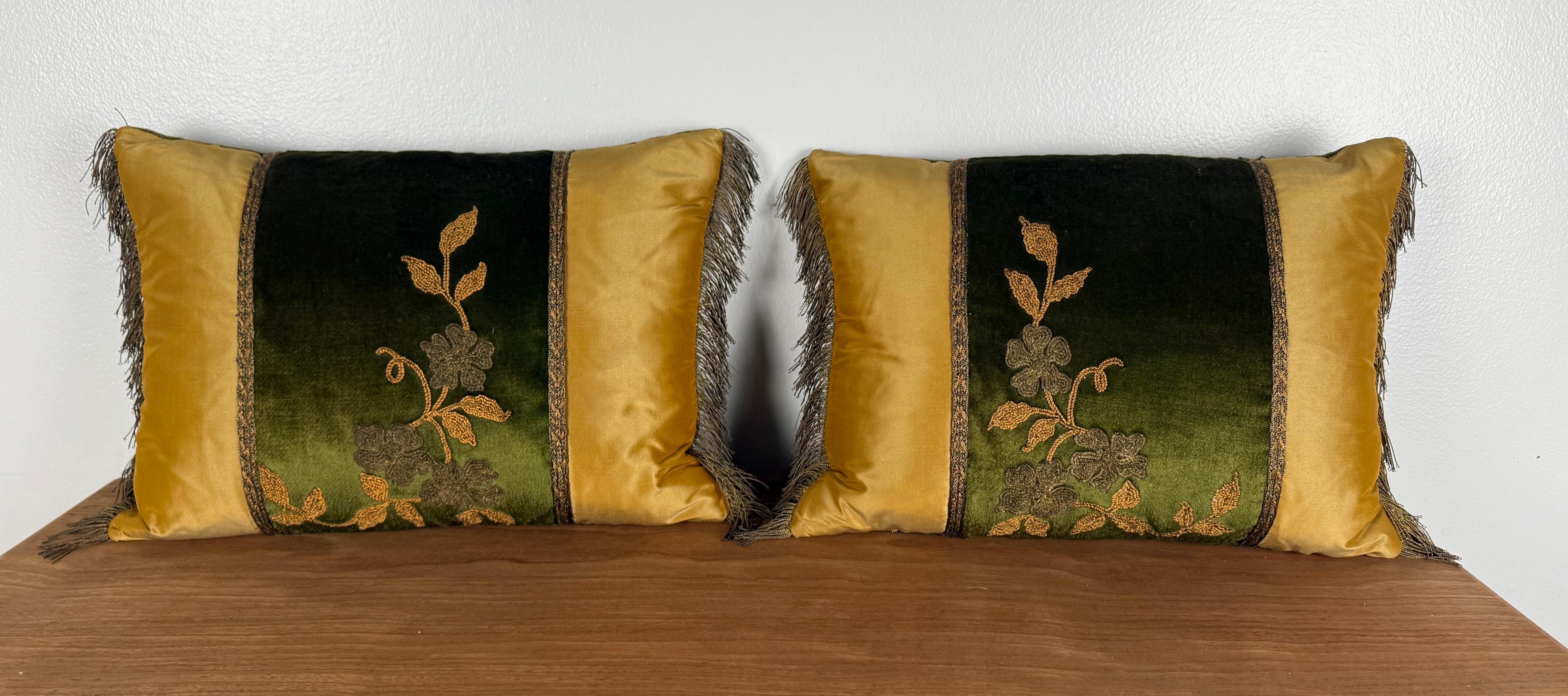 Une paire frappante de coussins personnalisés par la designer Melissa Levinson, créés en utilisant une combinaison raffinée de textiles français anciens et de matériaux de luxe contemporains. Les panneaux centraux présentent des appliqués brodés