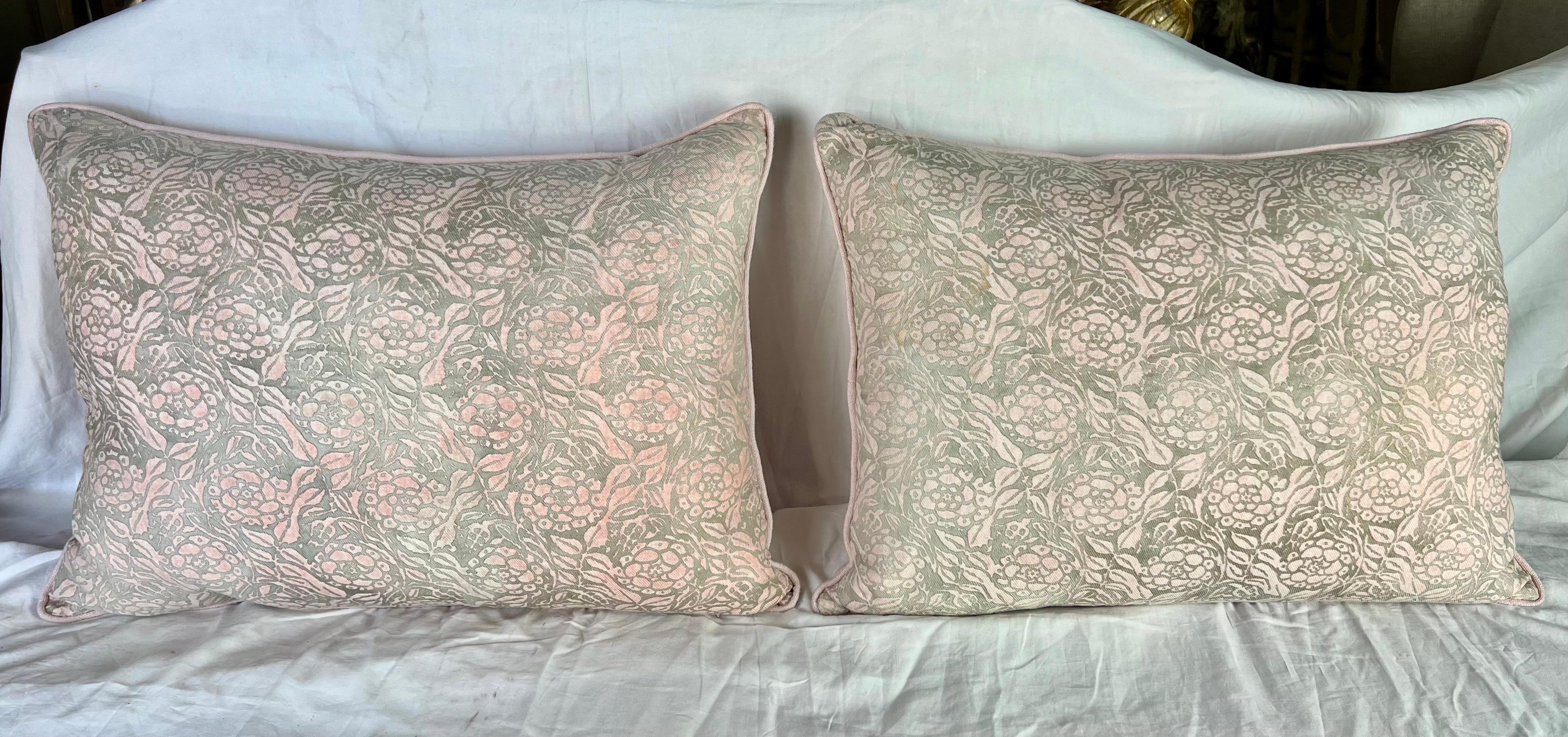 An exquisite pair of mid-20th-century Fortuny textile pillows in pink and gold, complemented by petal pink linen backs, designed by the talented Mariano Fortuny.