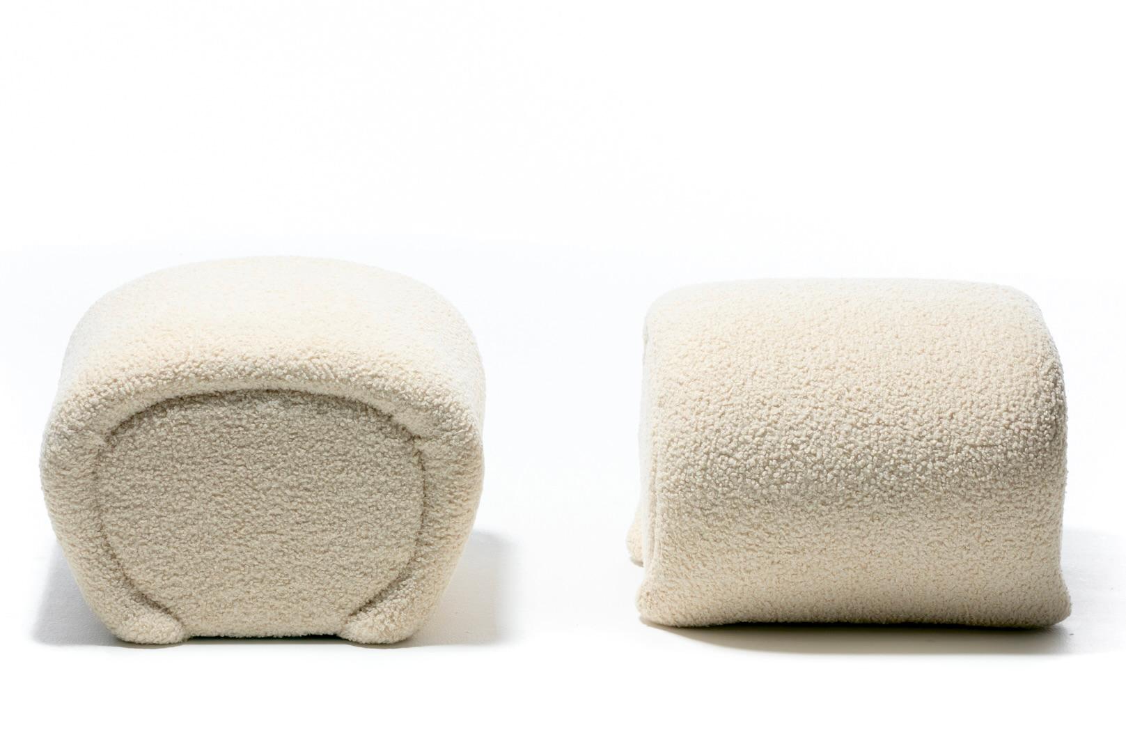 Curvy and soft Post Modern style sculptural ottomans freshly upholstered in plush highly durable ivory bouclé fabric. Reminiscent of Karl Springer's iconic Waterfall Ottomans or Benches, the ottomans' sides curve in a similar waterfall fashion